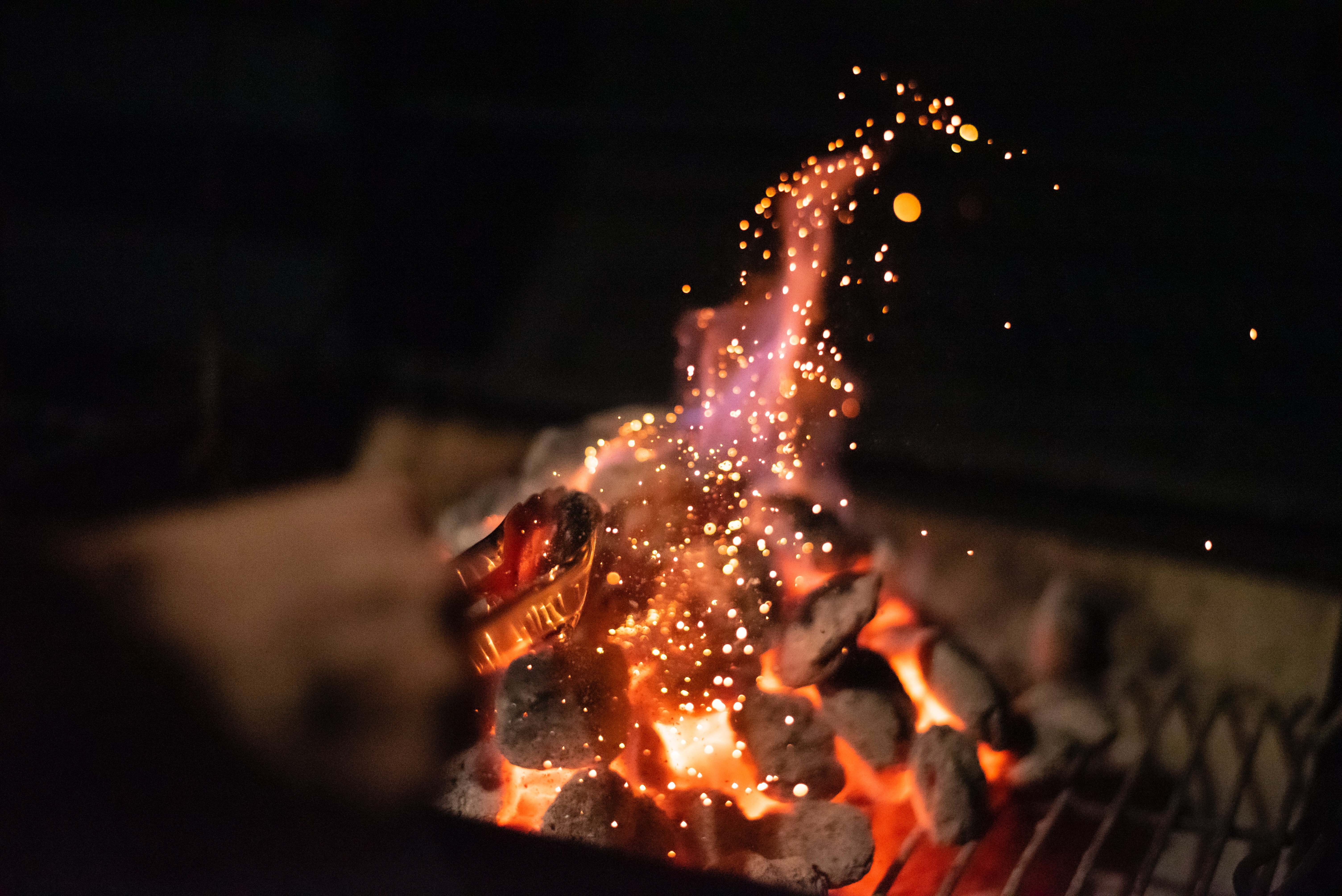 Kol som glöder och brinner på en grill. 