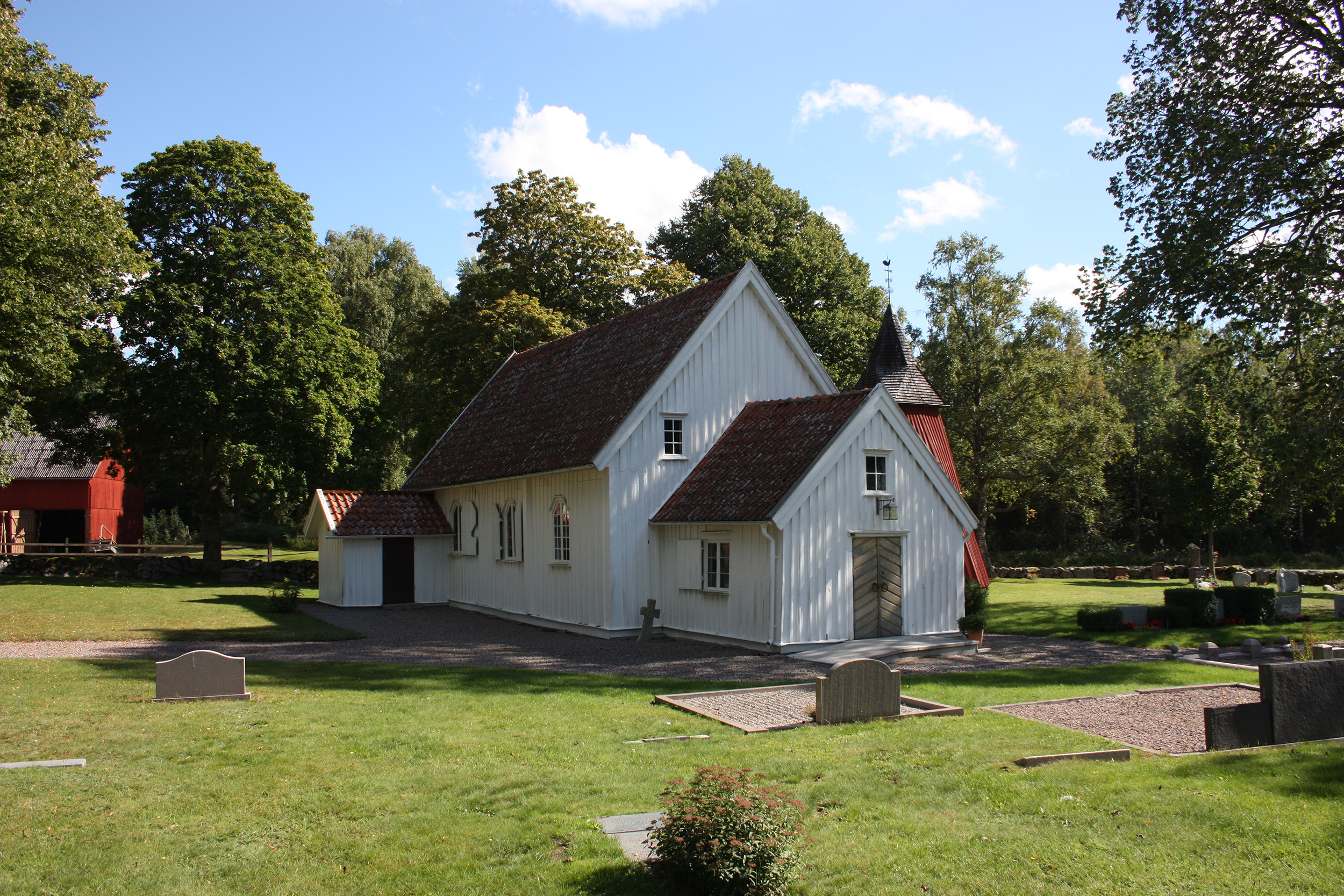 en vit träkyrka med gräs framför