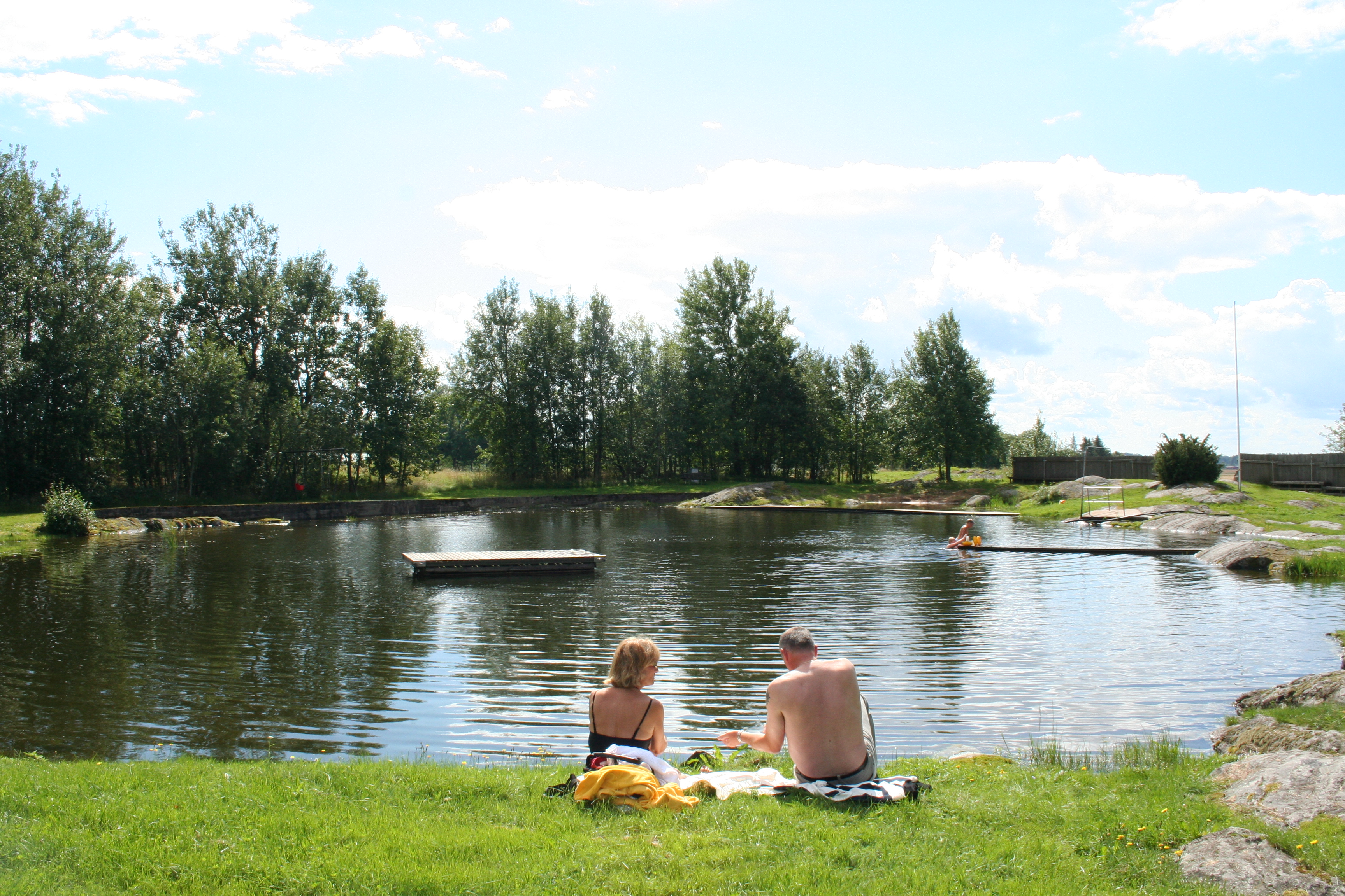En liten badsjö i ett grönskande landskap