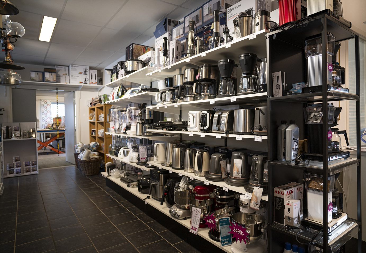 Kaffeapparater som står på hyllor i en butik.