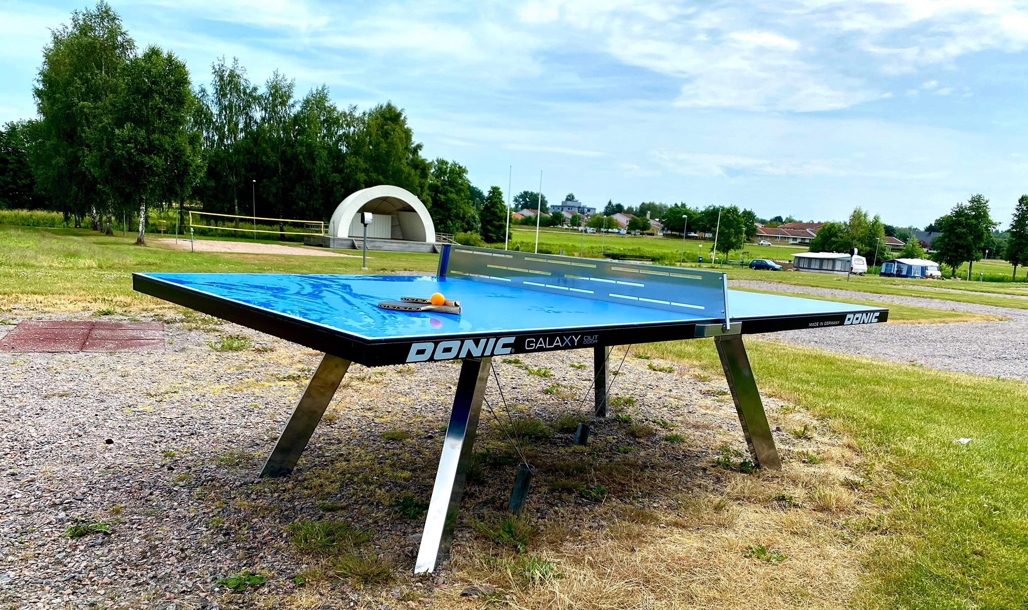 Ett blått pingisbord som står ute. 
