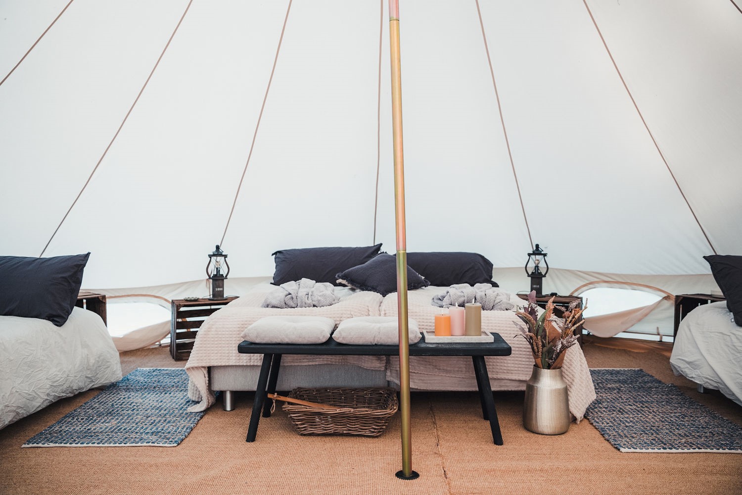 Inne i ett glamping tält med sängar och inredning. 