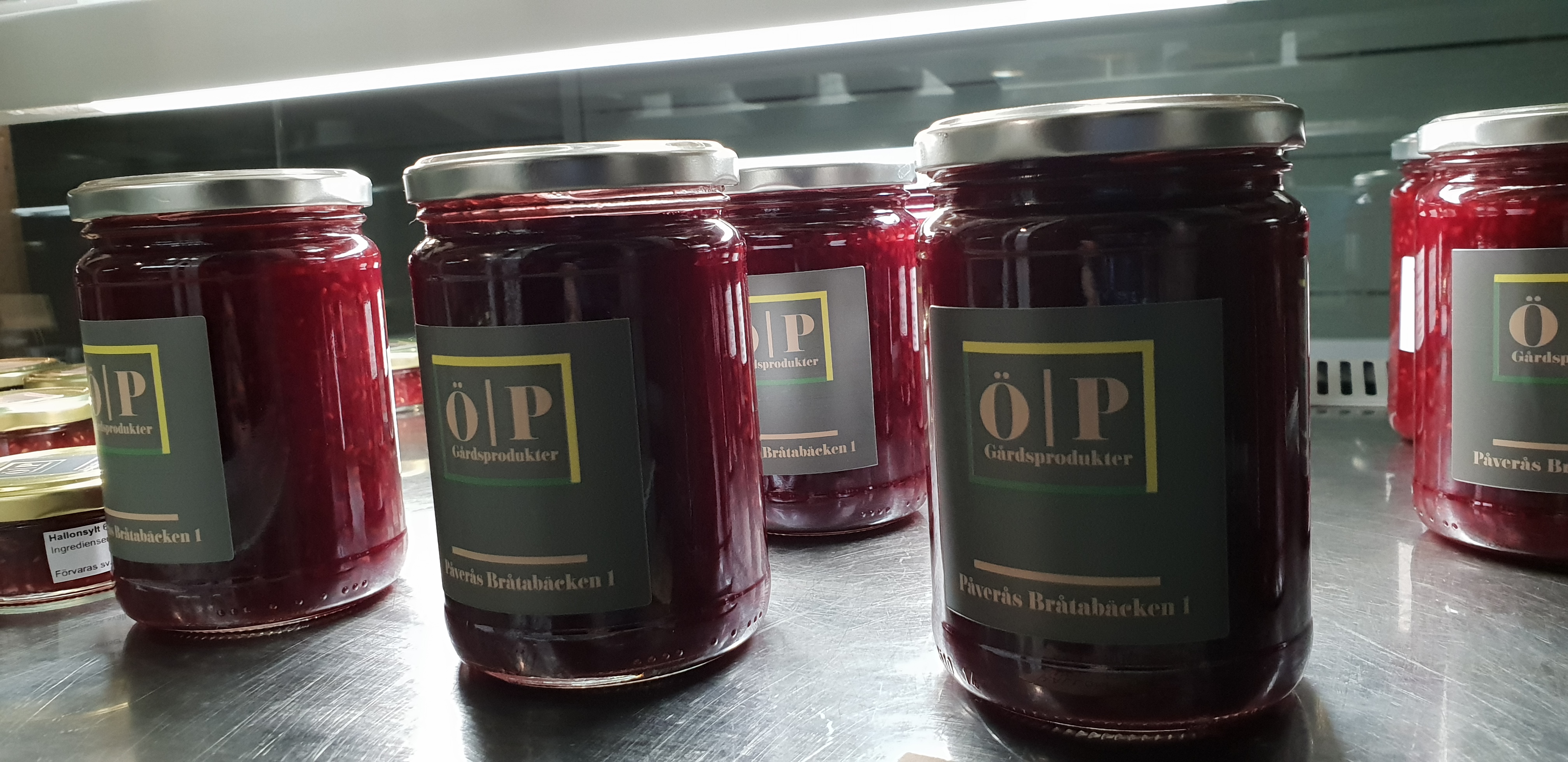 Burkar med sylt och gråa etiketter med texten ÖP gårdsprodukter.