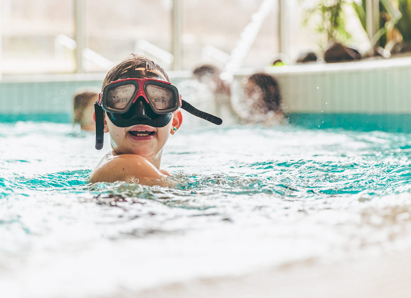 Pojke med cyklop som är i poolen.