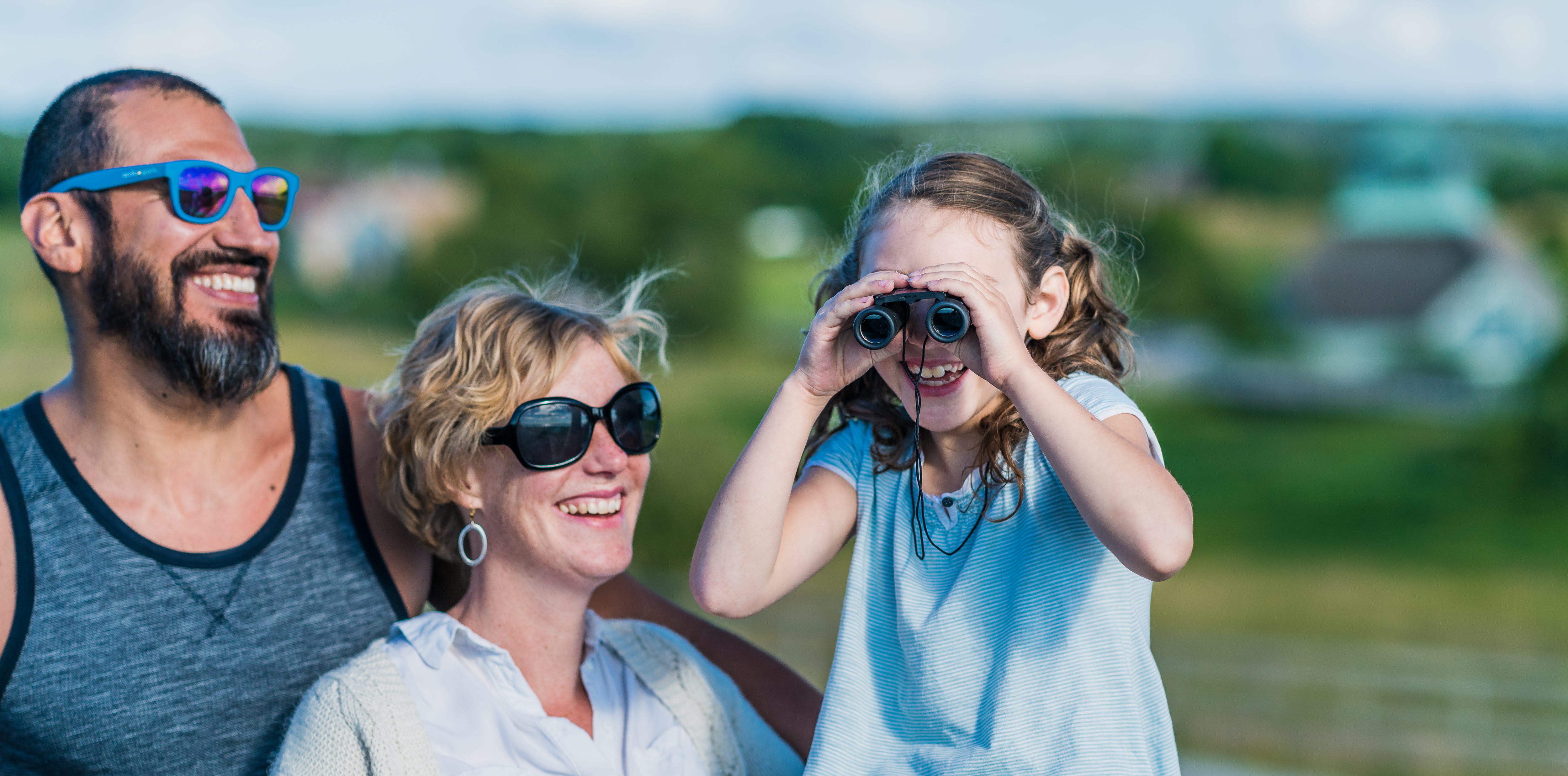 En kvinna, en man och ett barn. närbild. Barnet kikar i en kikare.