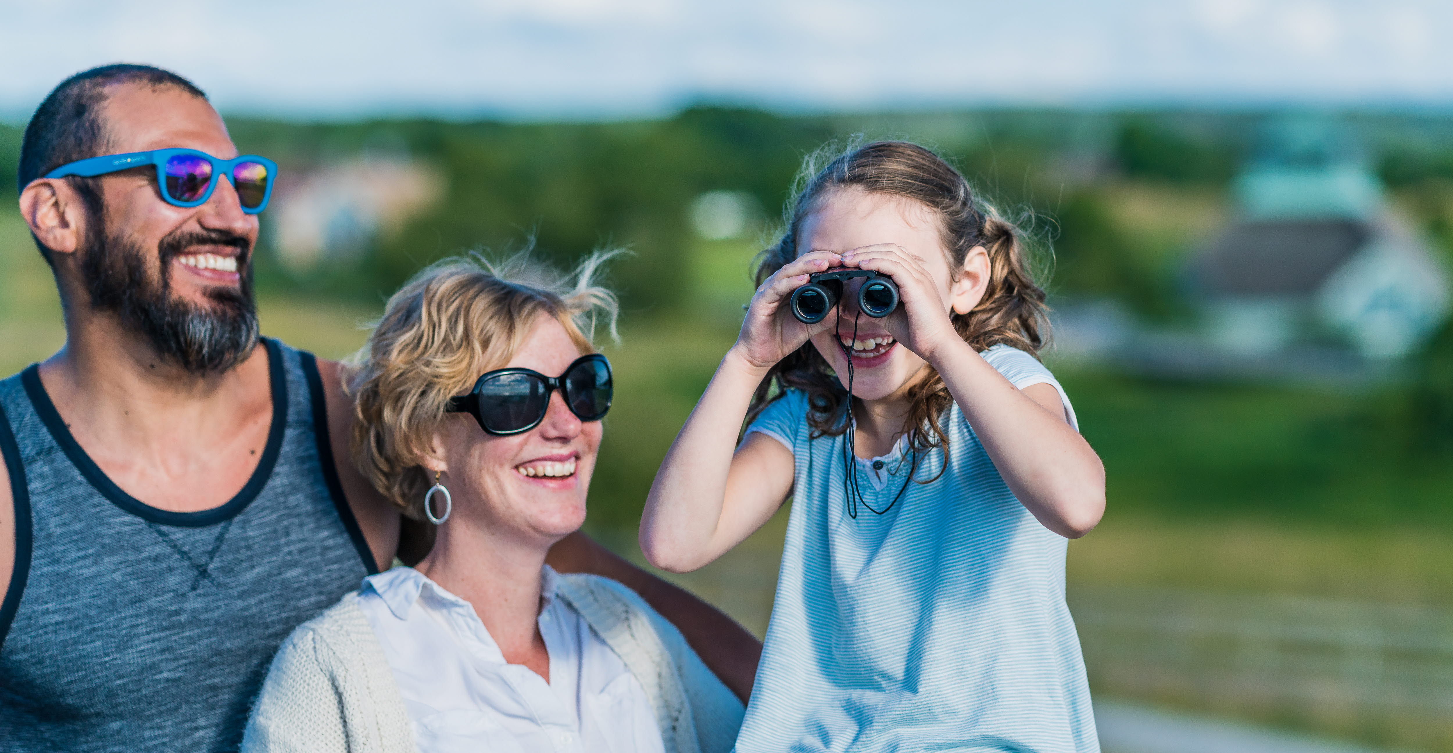 En kvinna, en man och ett barn. närbild. Barnet kikar i en kikare.