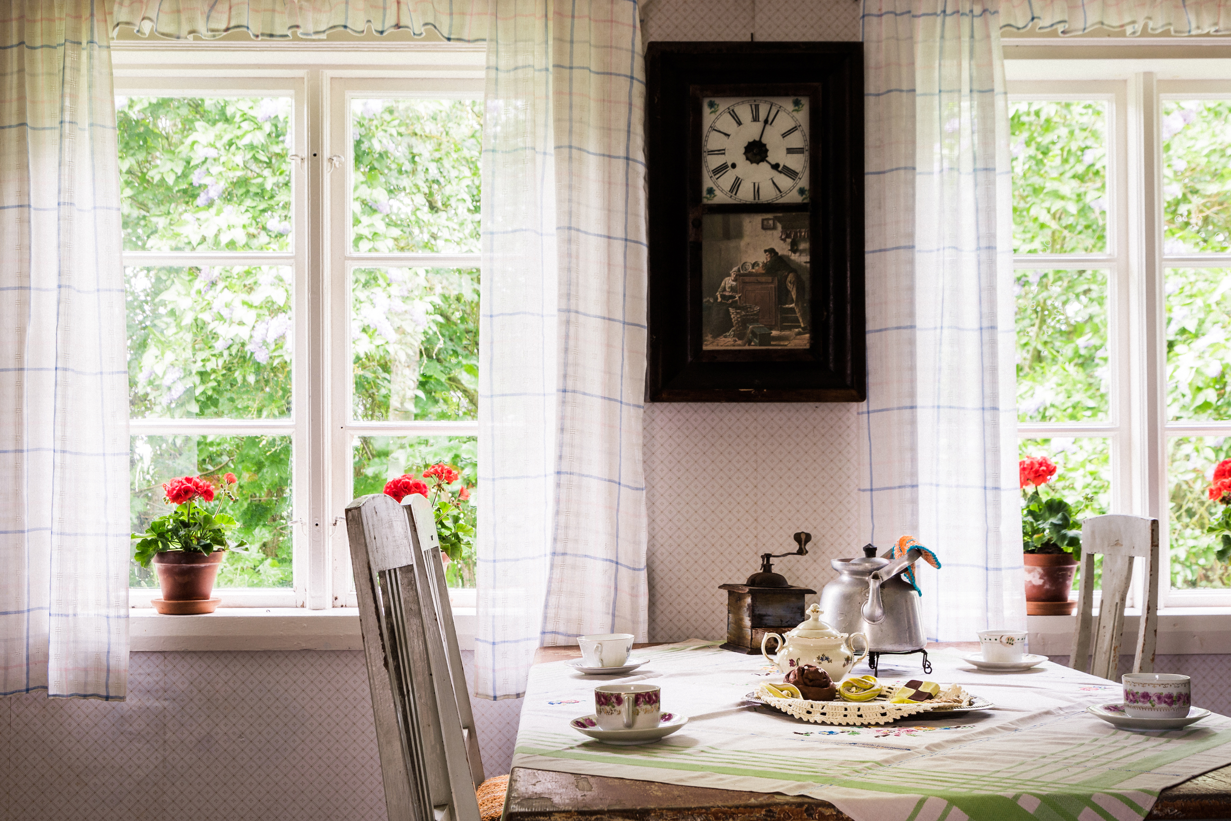 Interiörbild från en stuga med ett dukat bord med fika.