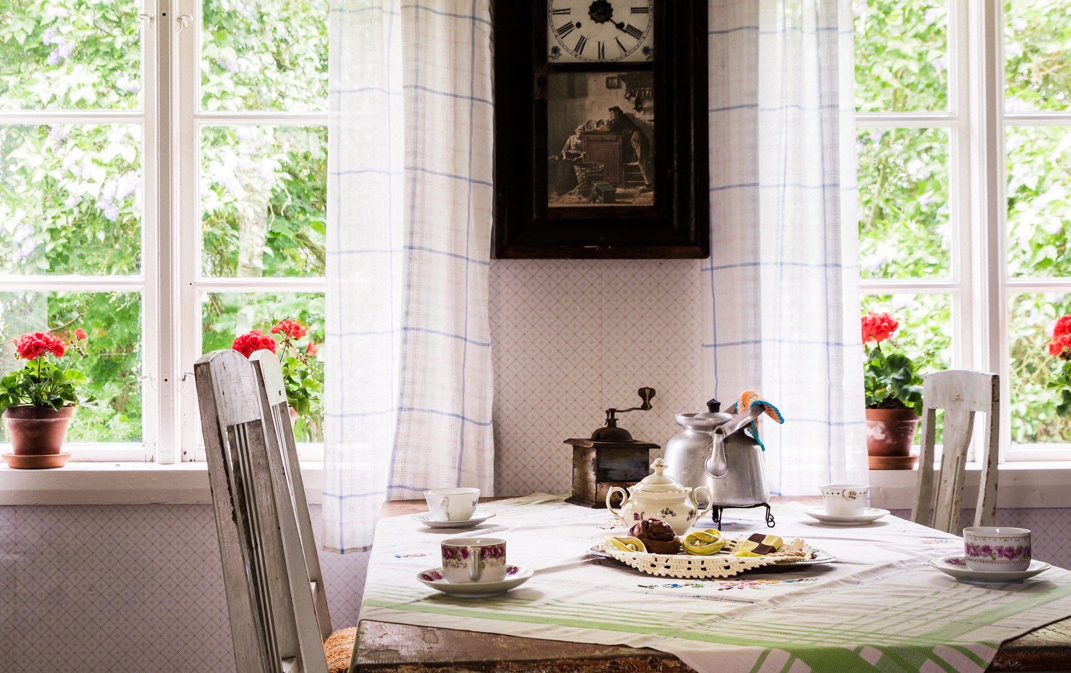 Interiörbild från en stuga med ett dukat bord med fika.