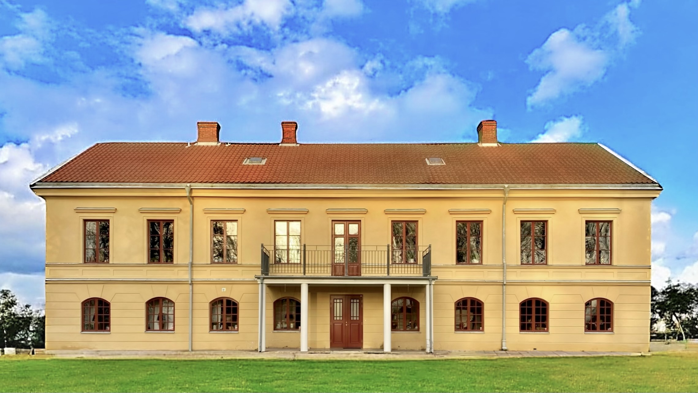 En stor gul herrgårdsbyggnad.