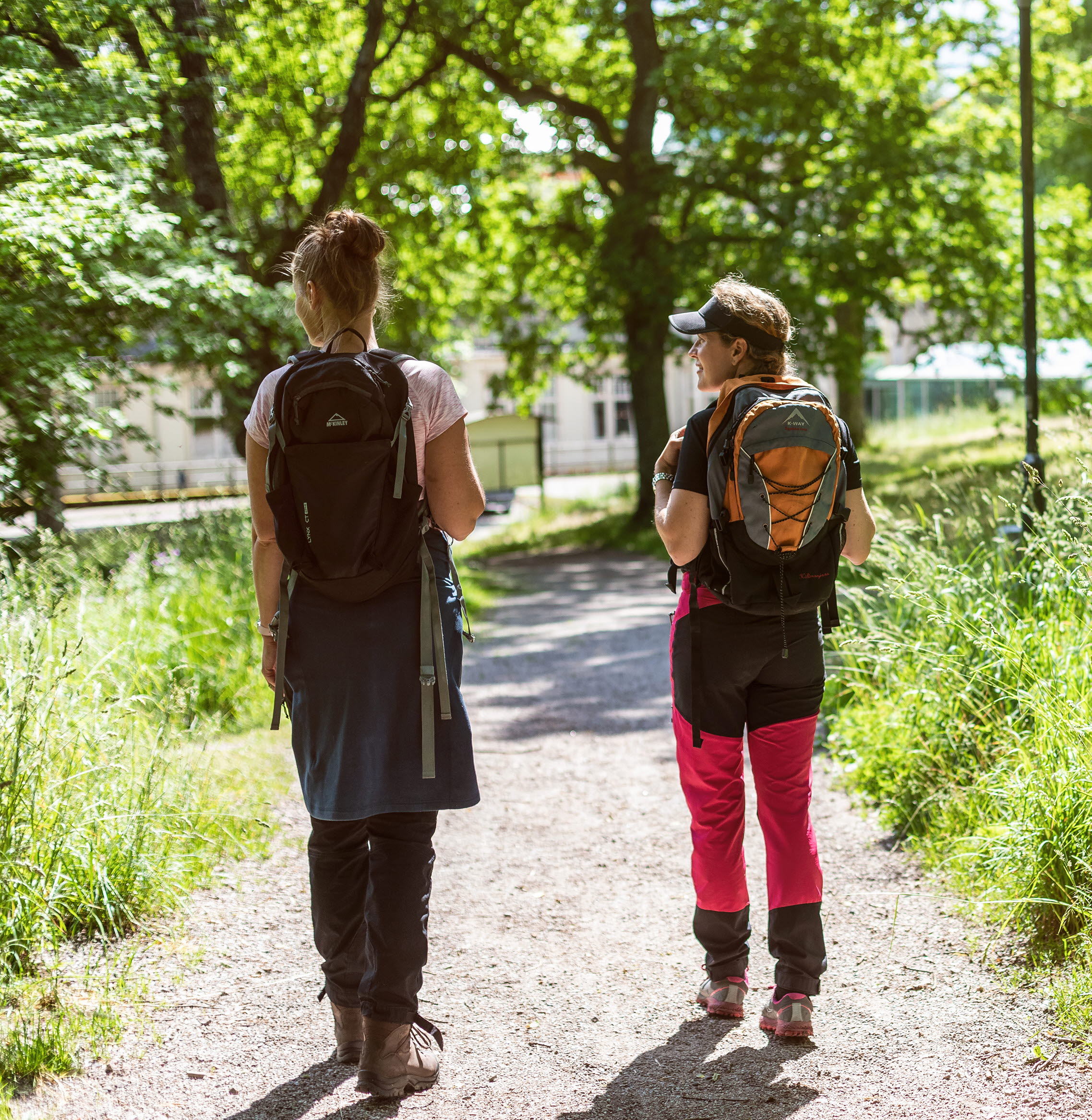 Två tjejer som vandrar med ryggsäckar.