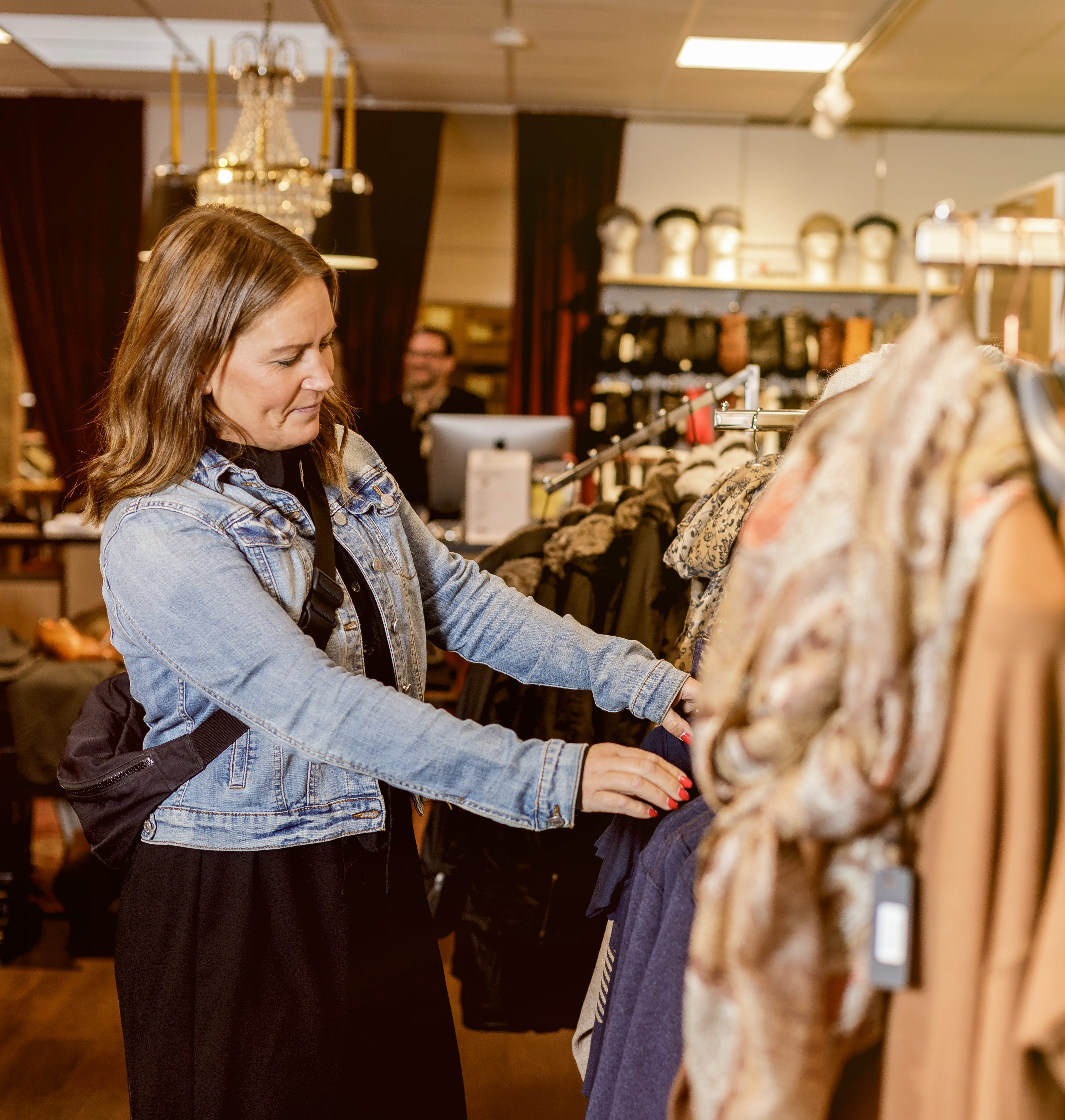 Kvinna som kikar på kläder i en butik.