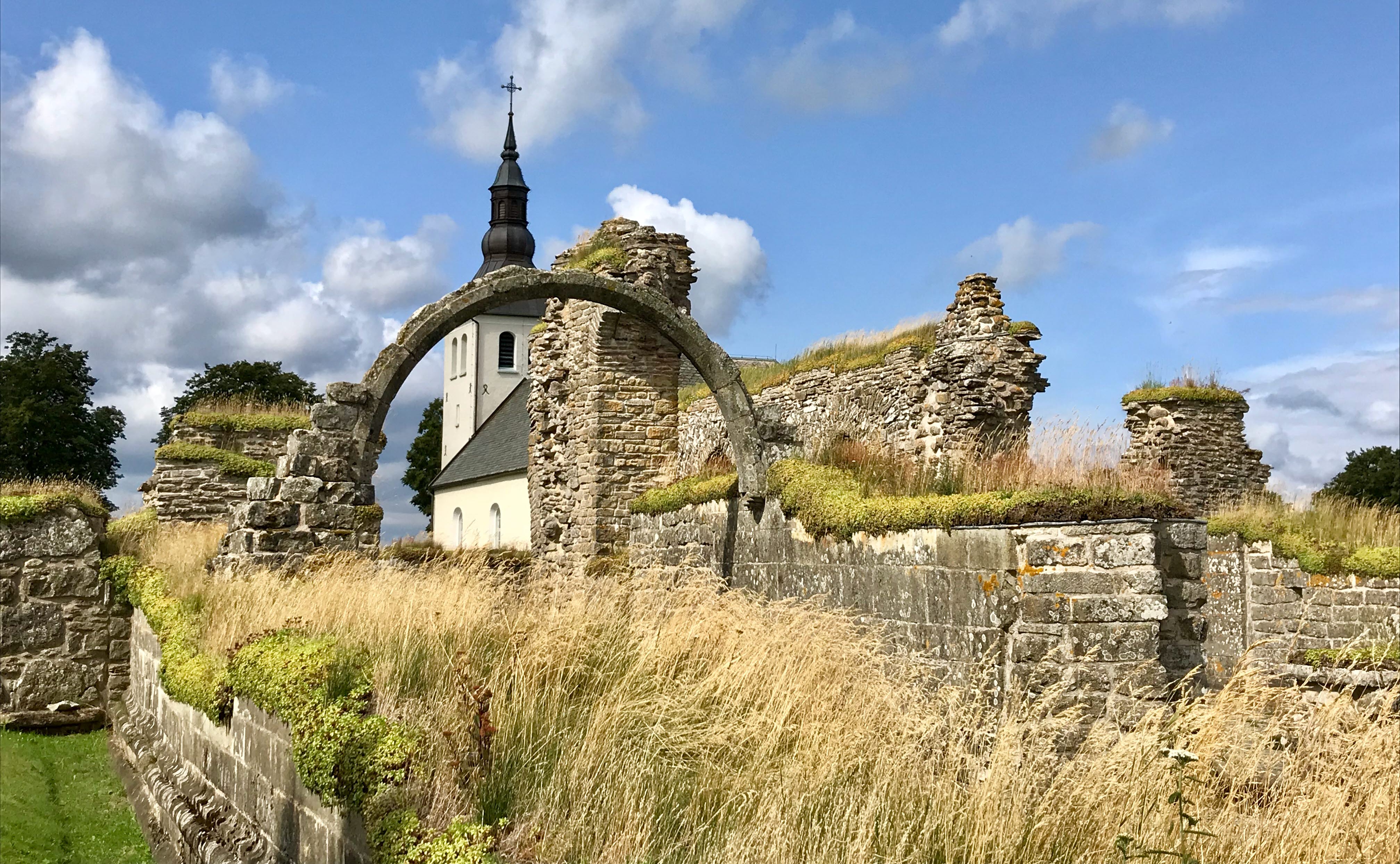 Gudhems klosterruin med Gudhems kyrka i bakgrunden.