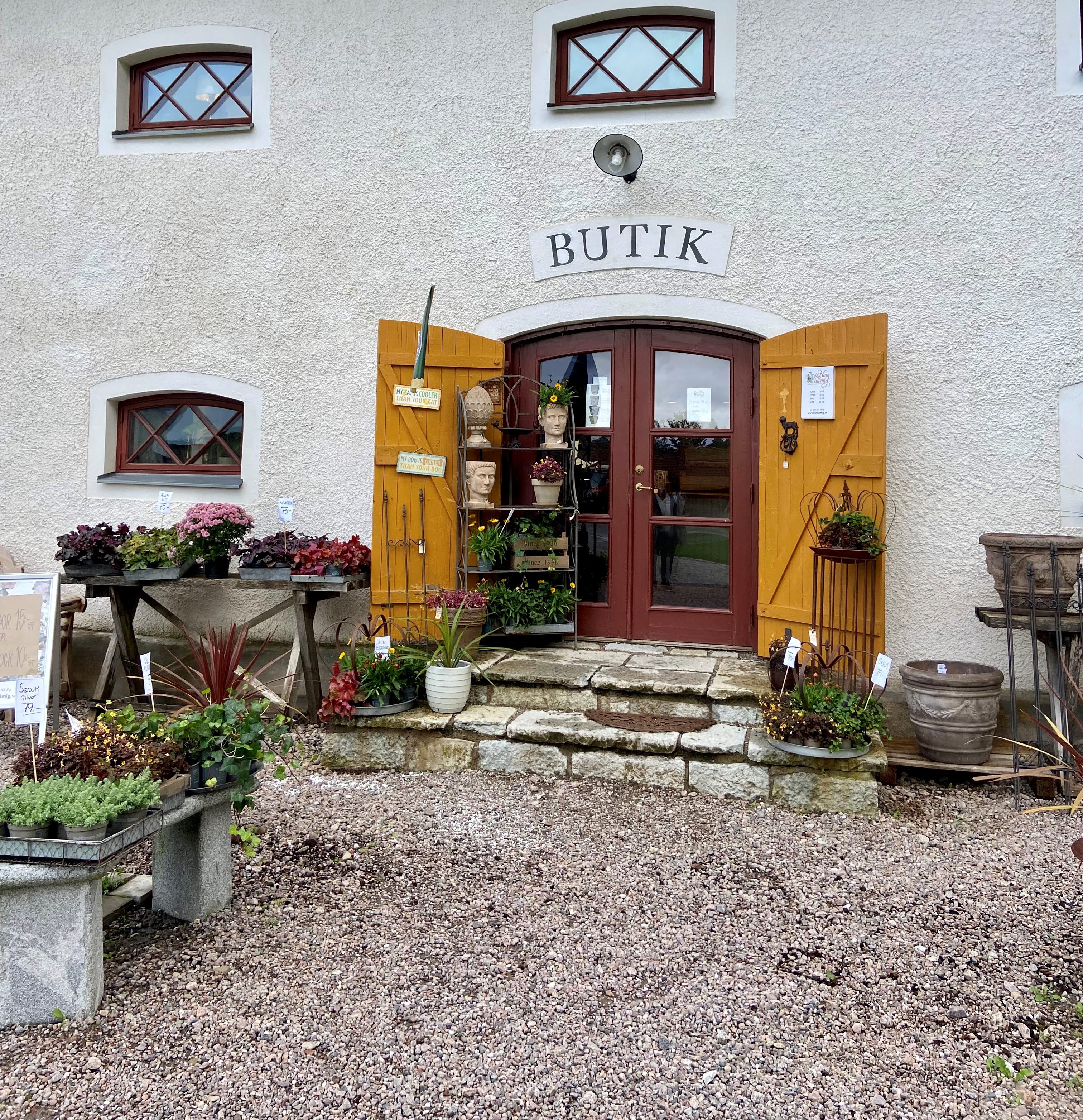 Vit byggnad i sten med blommor utanför.