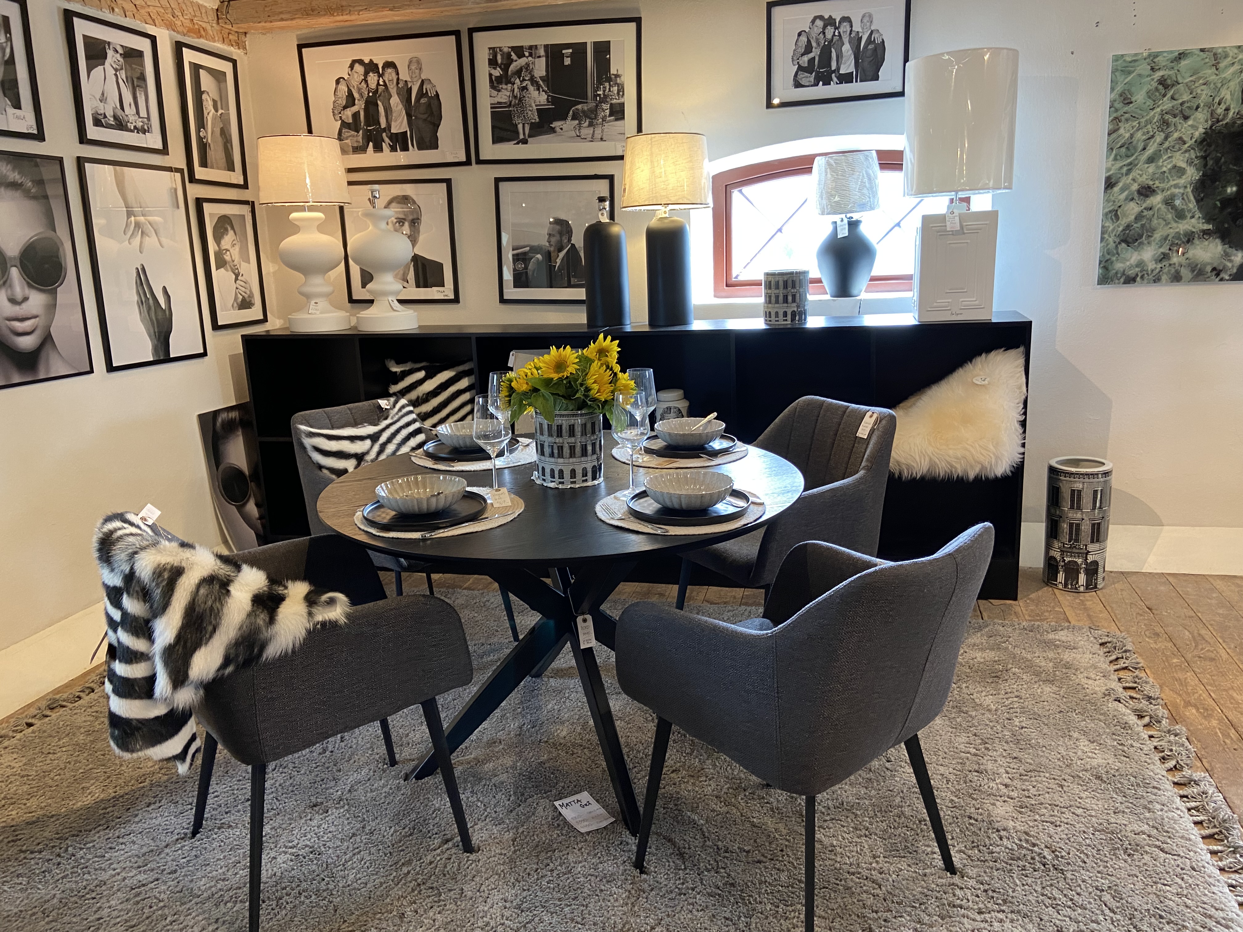 Dining group with a black round table and chairs in gray fabric.