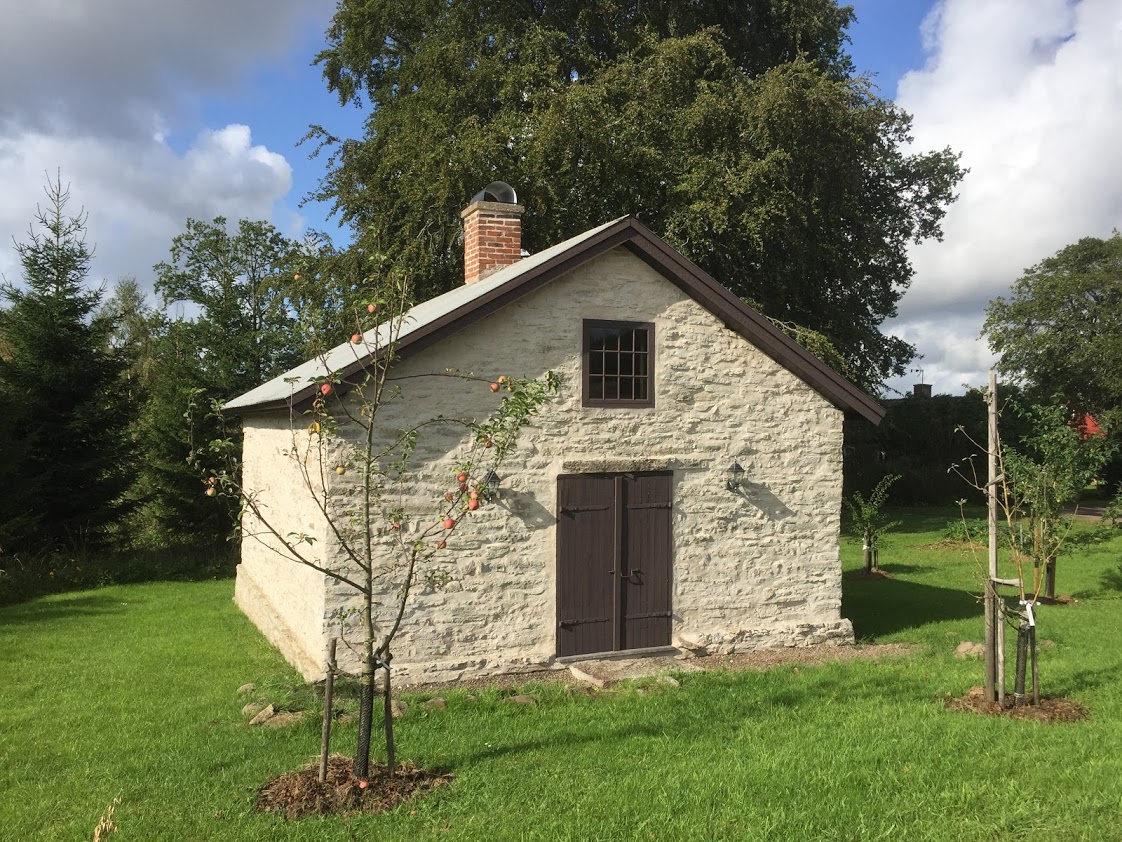 Exteriörbild på smedjan, ett stenhus i ljusgrått 