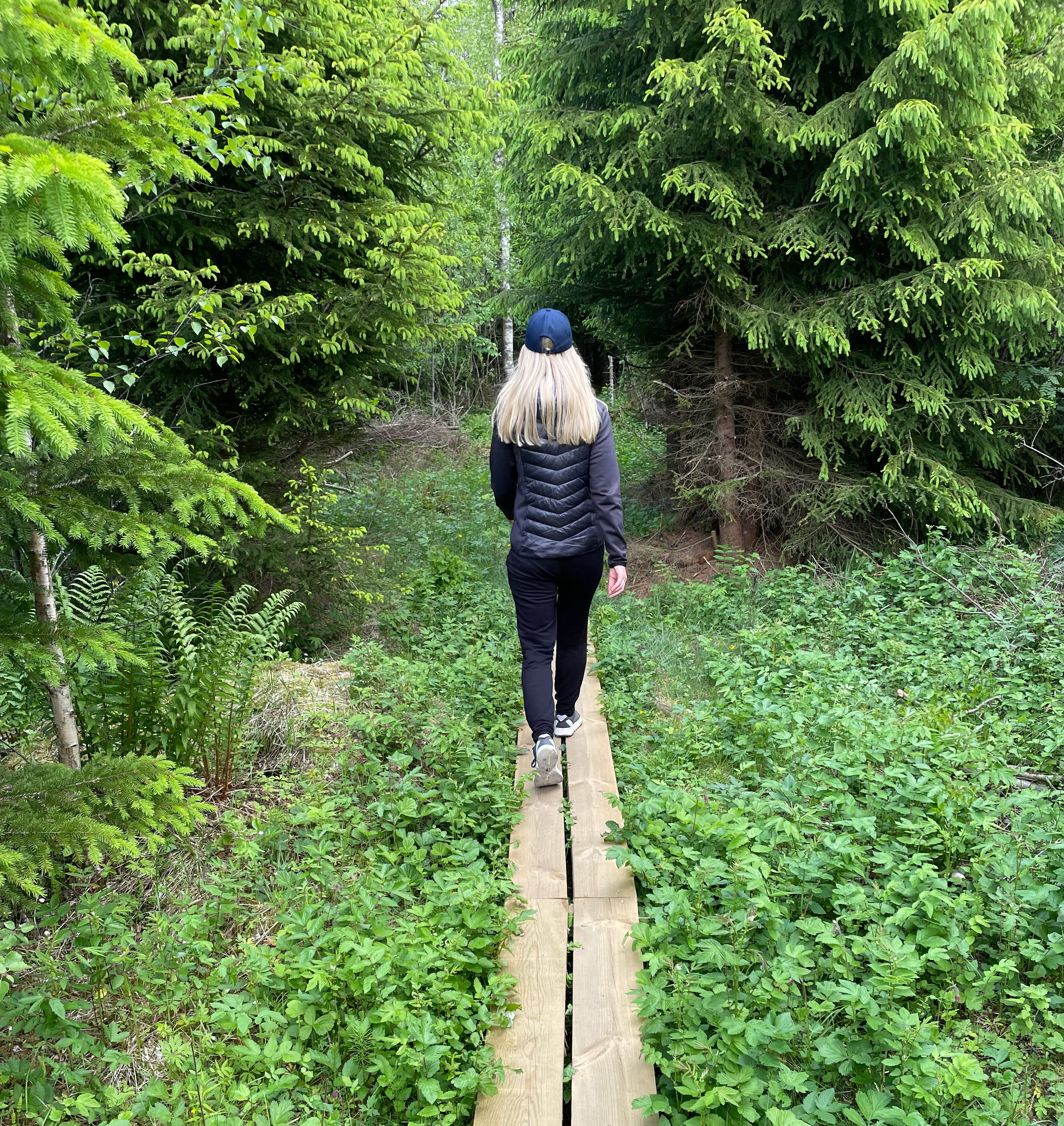 en kvinna som går på en spång ute i naturen