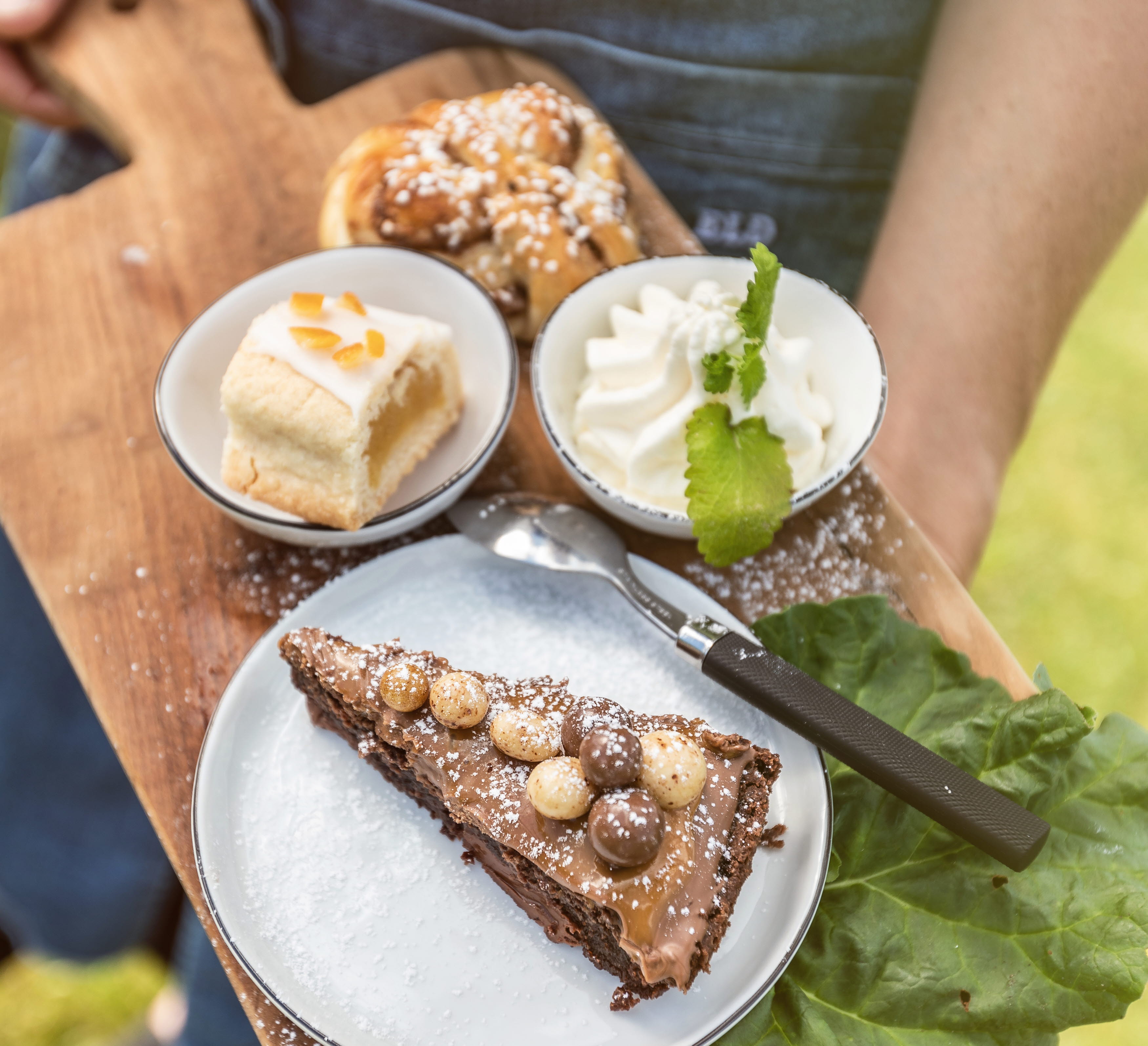 Kladdkaka, bulle och en kaka på en träbräda.