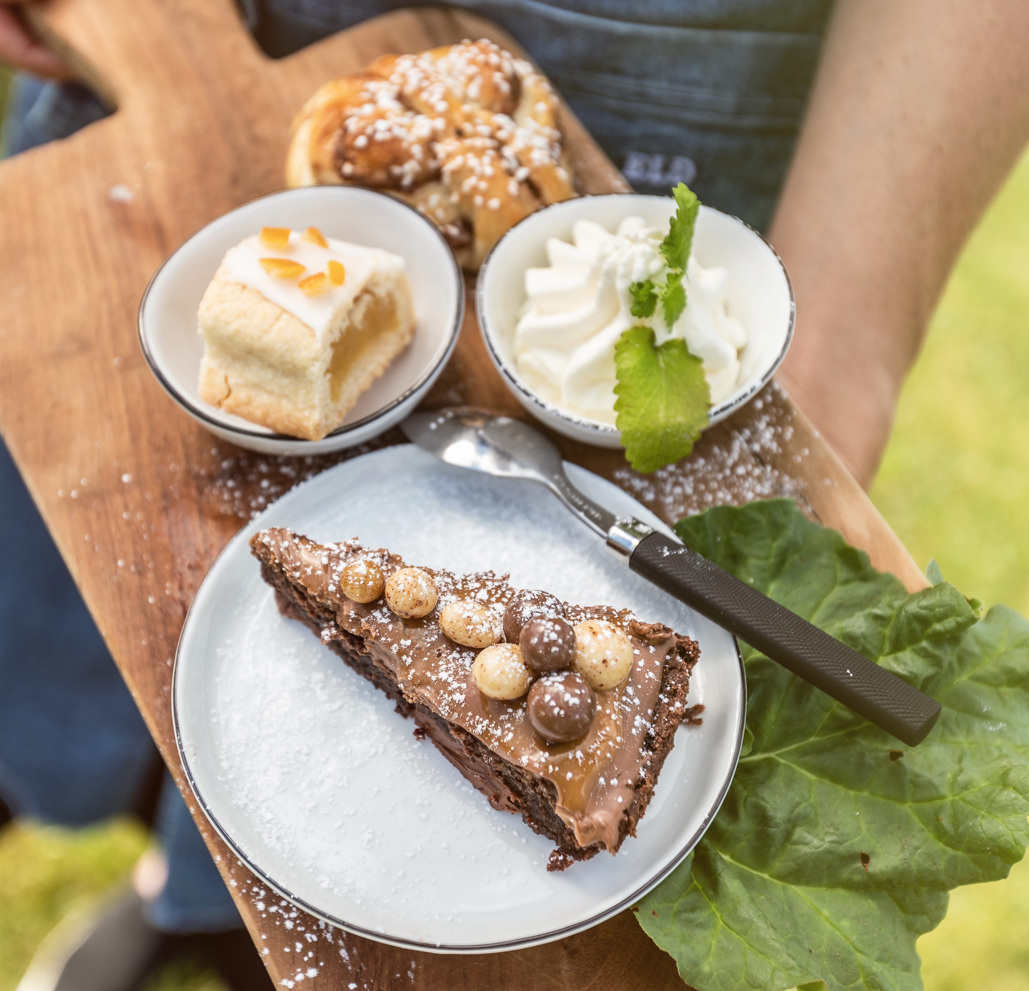Kladdkaka, bulle och en kaka på en träbräda.