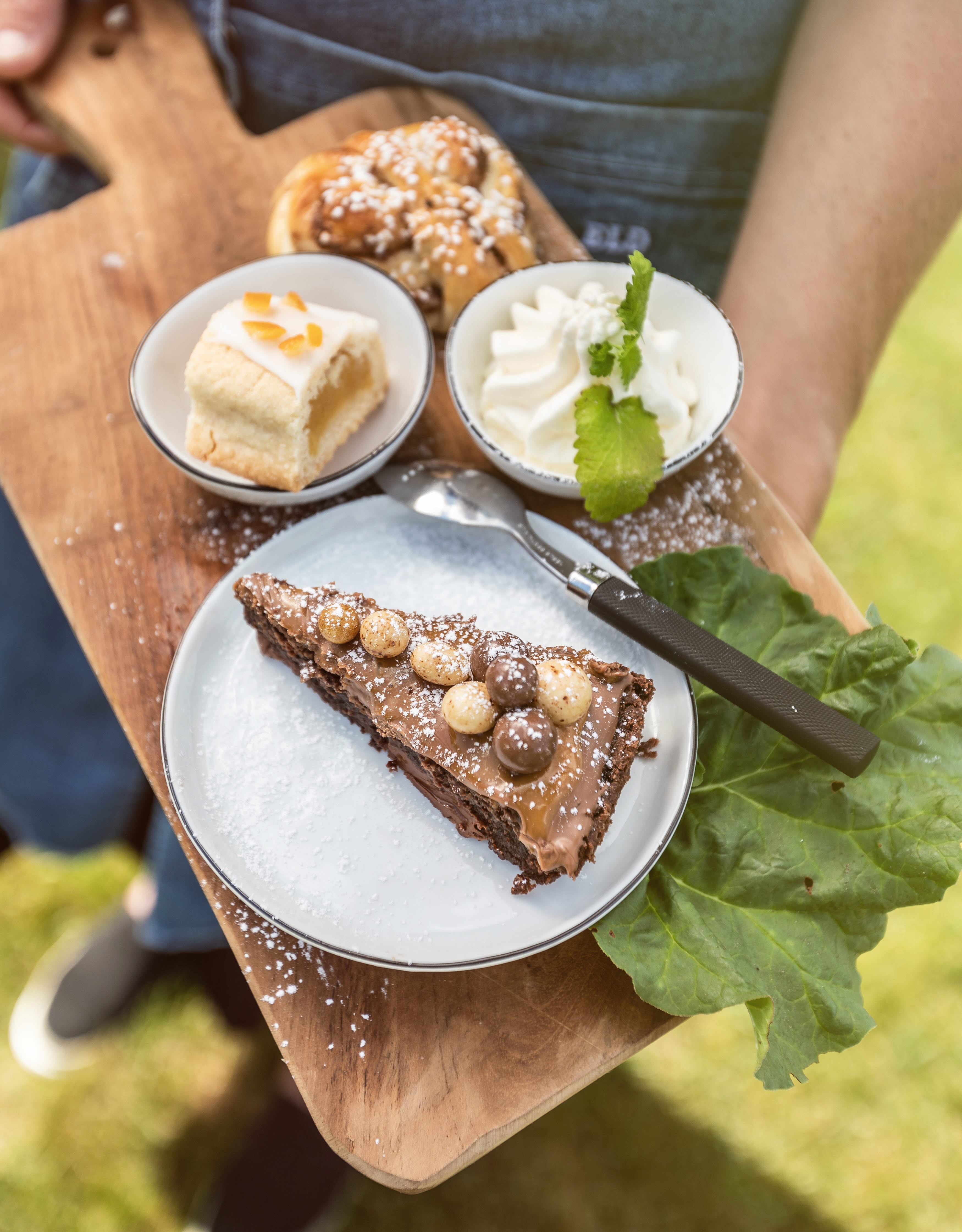 Kladdkaka, bulle och en kaka på en träbräda.