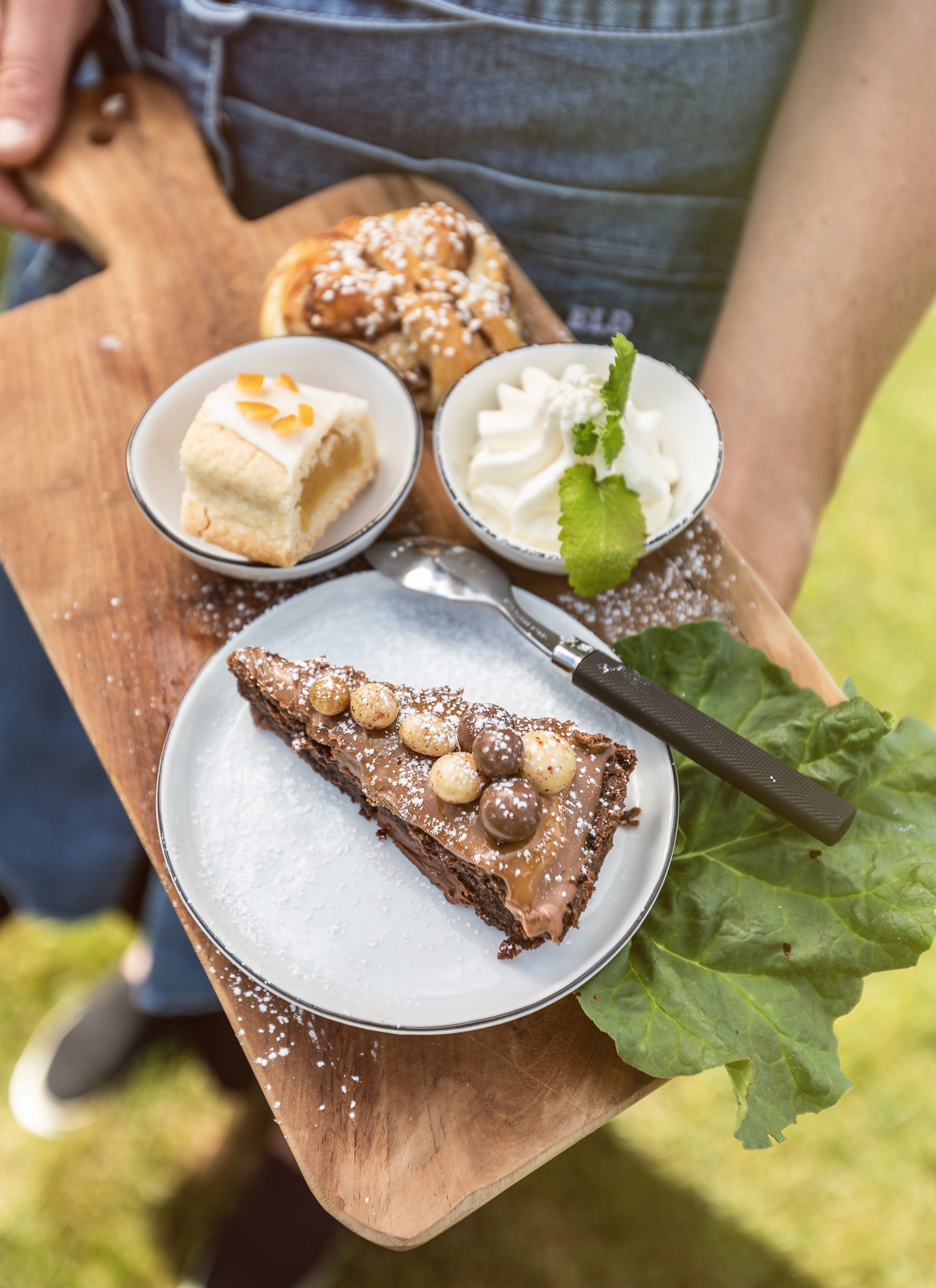 Kladdkaka, bulle och en kaka på en träbräda.