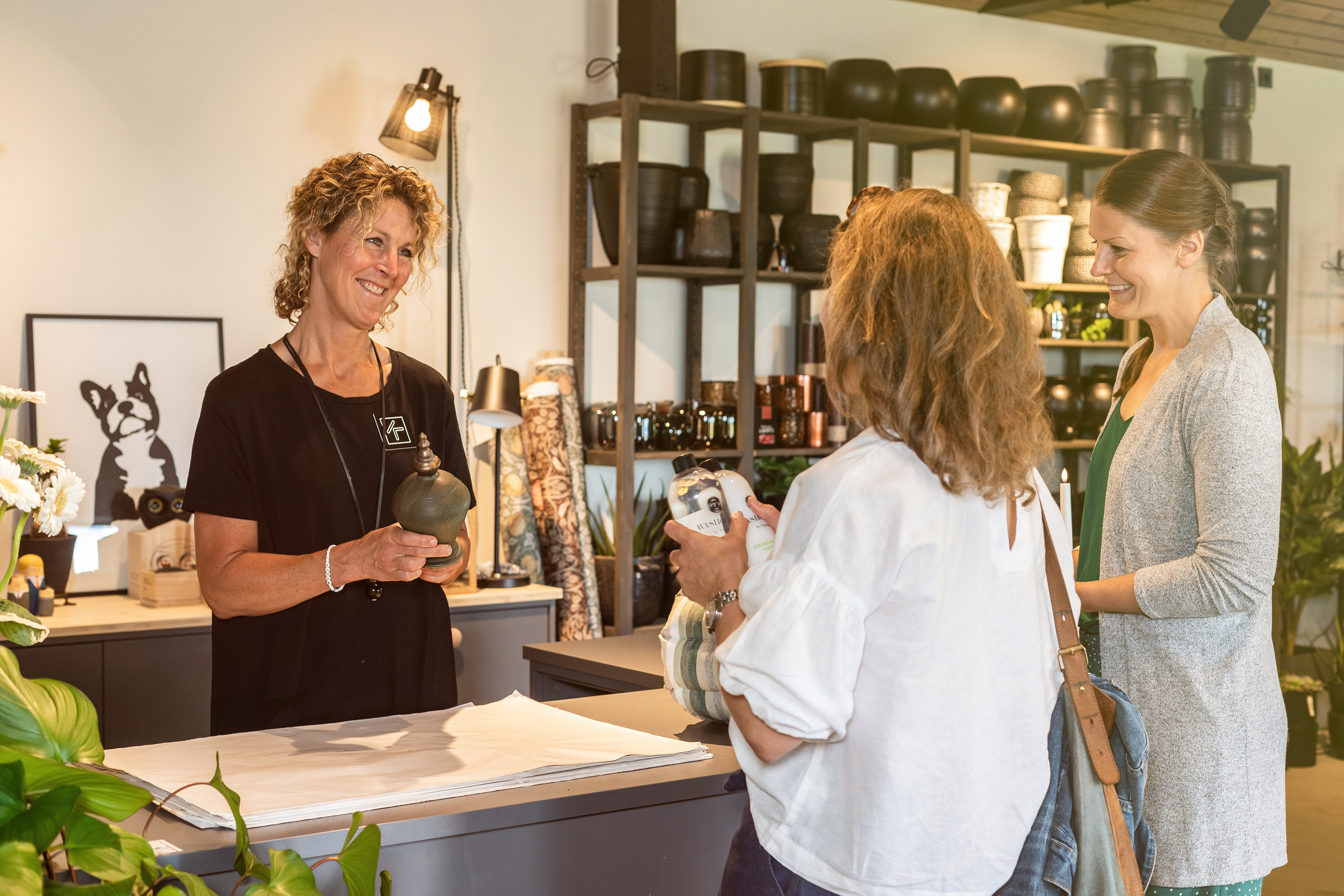 Två kvinnor som handlar inredning av butiksinnehavaren.