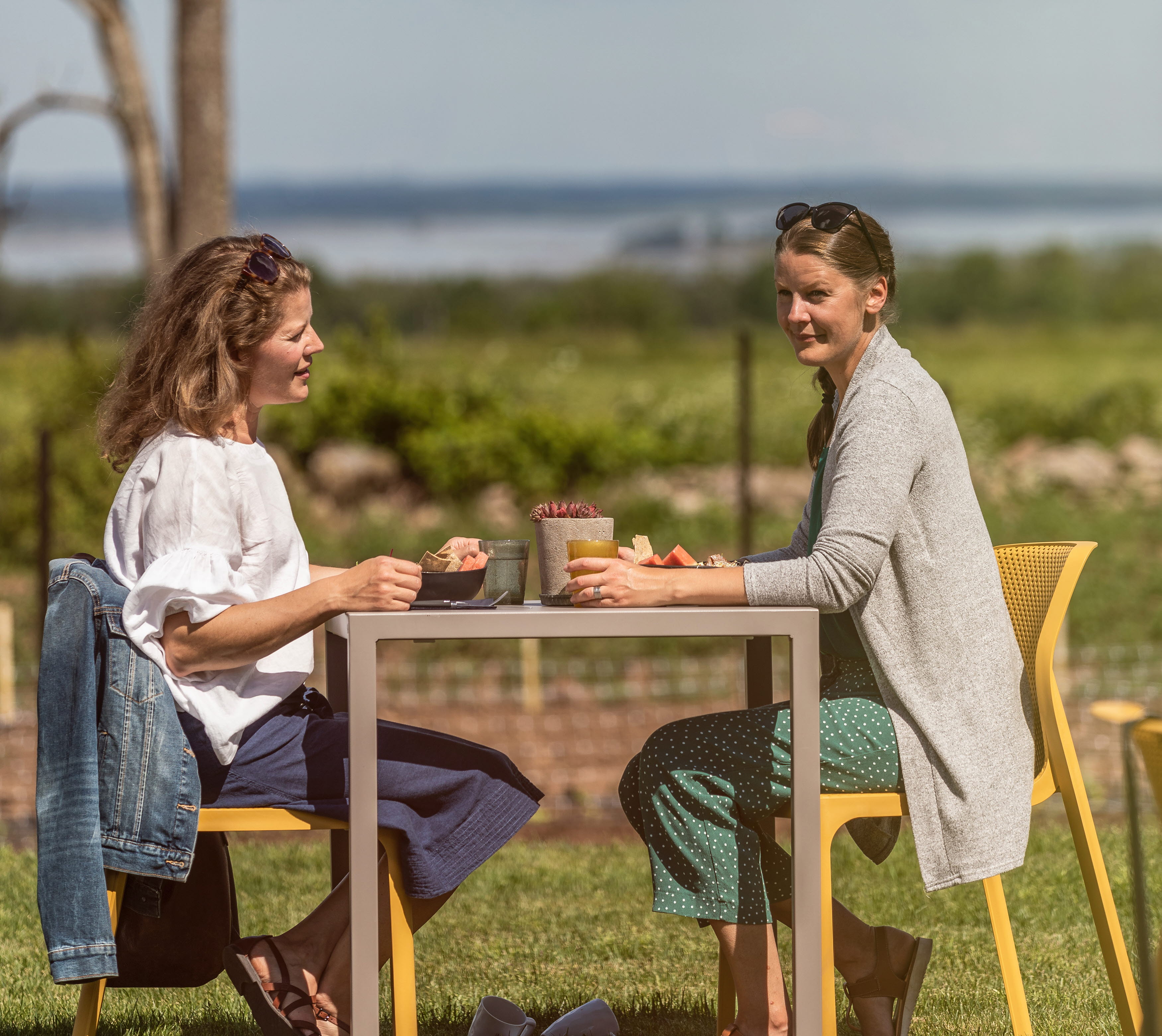 Två kvinnor som sitter på uteserveringen och fikar.