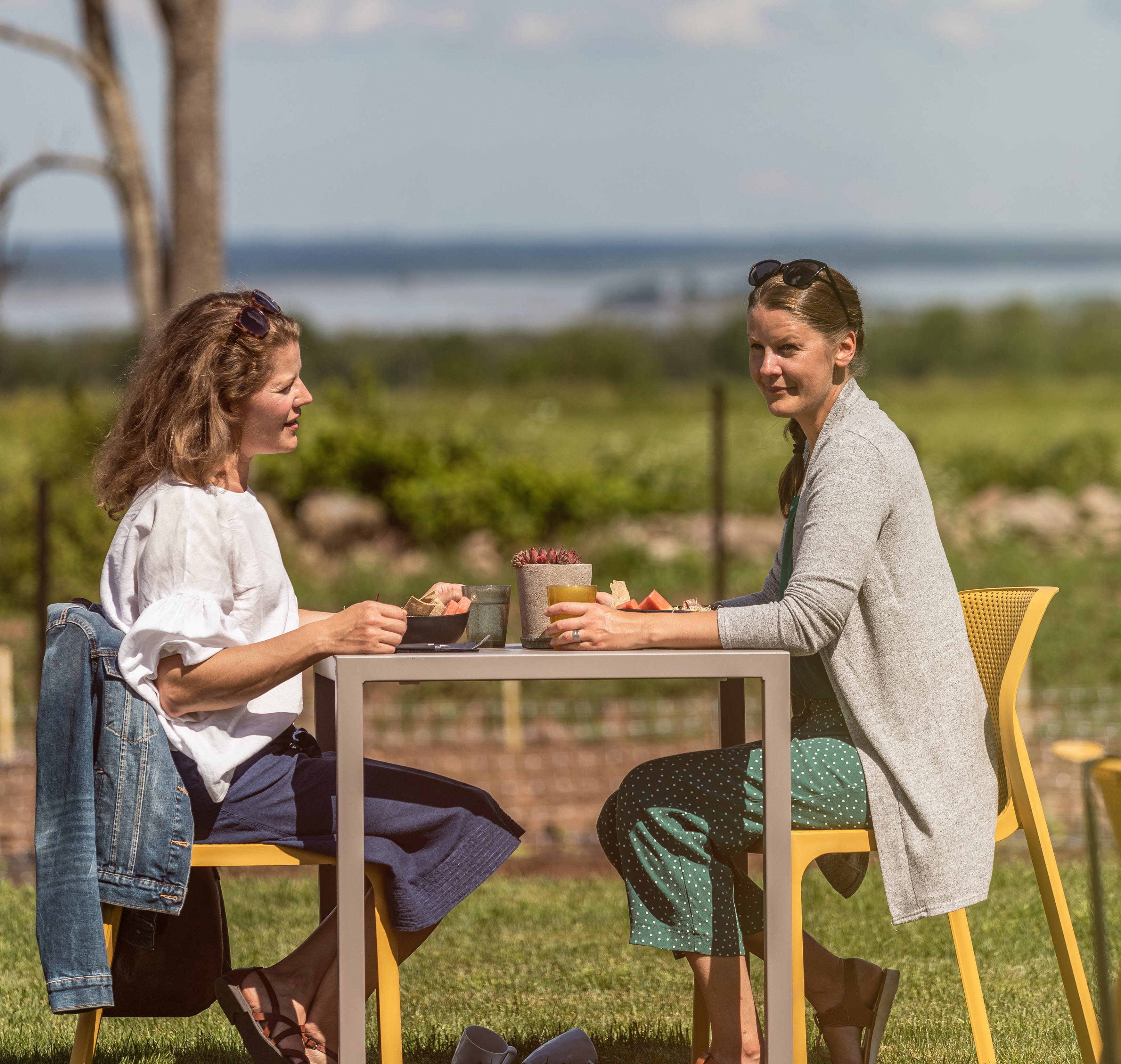 Två kvinnor som sitter på uteserveringen och fikar.