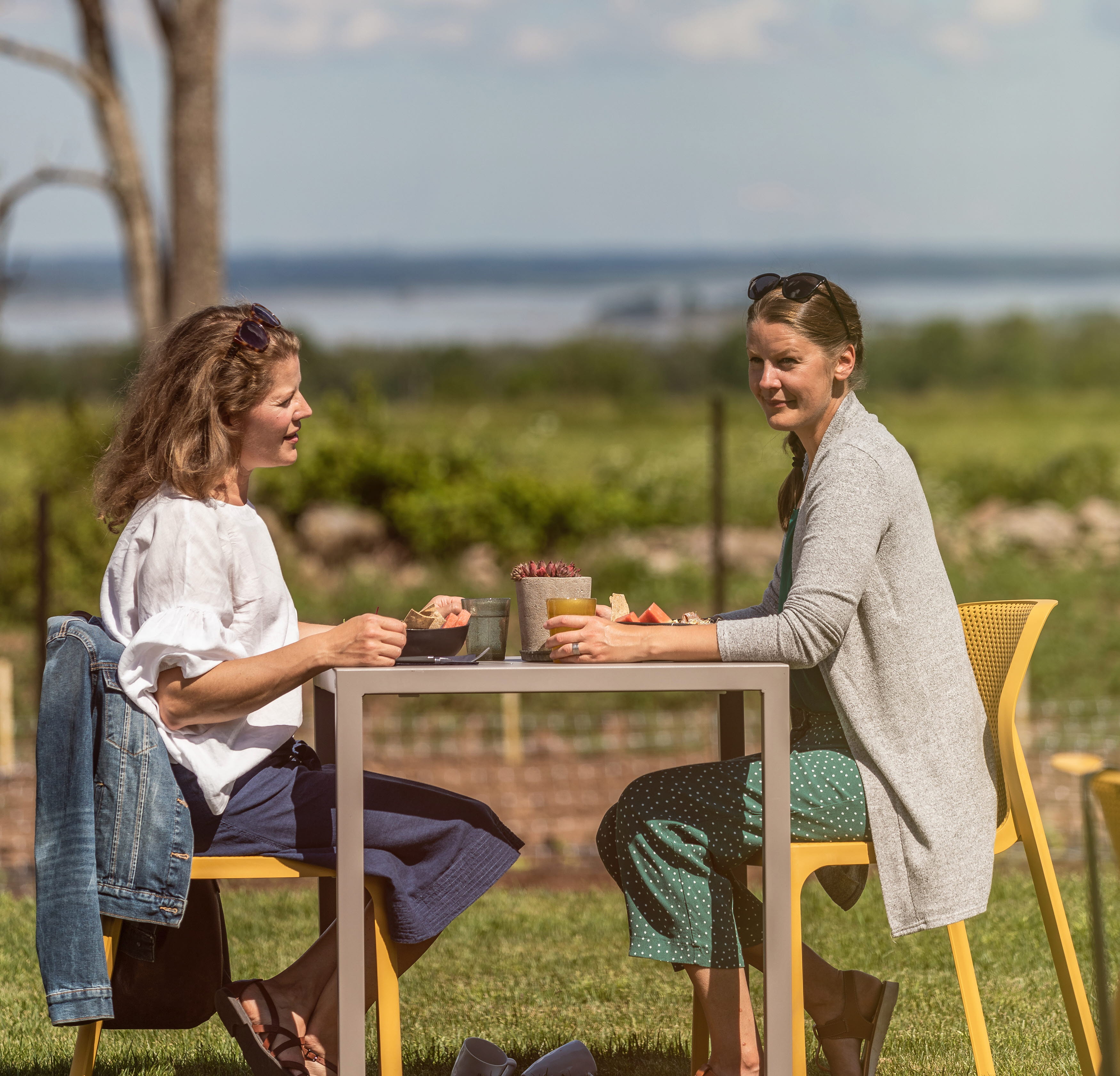 Två kvinnor som sitter på uteserveringen och fikar.