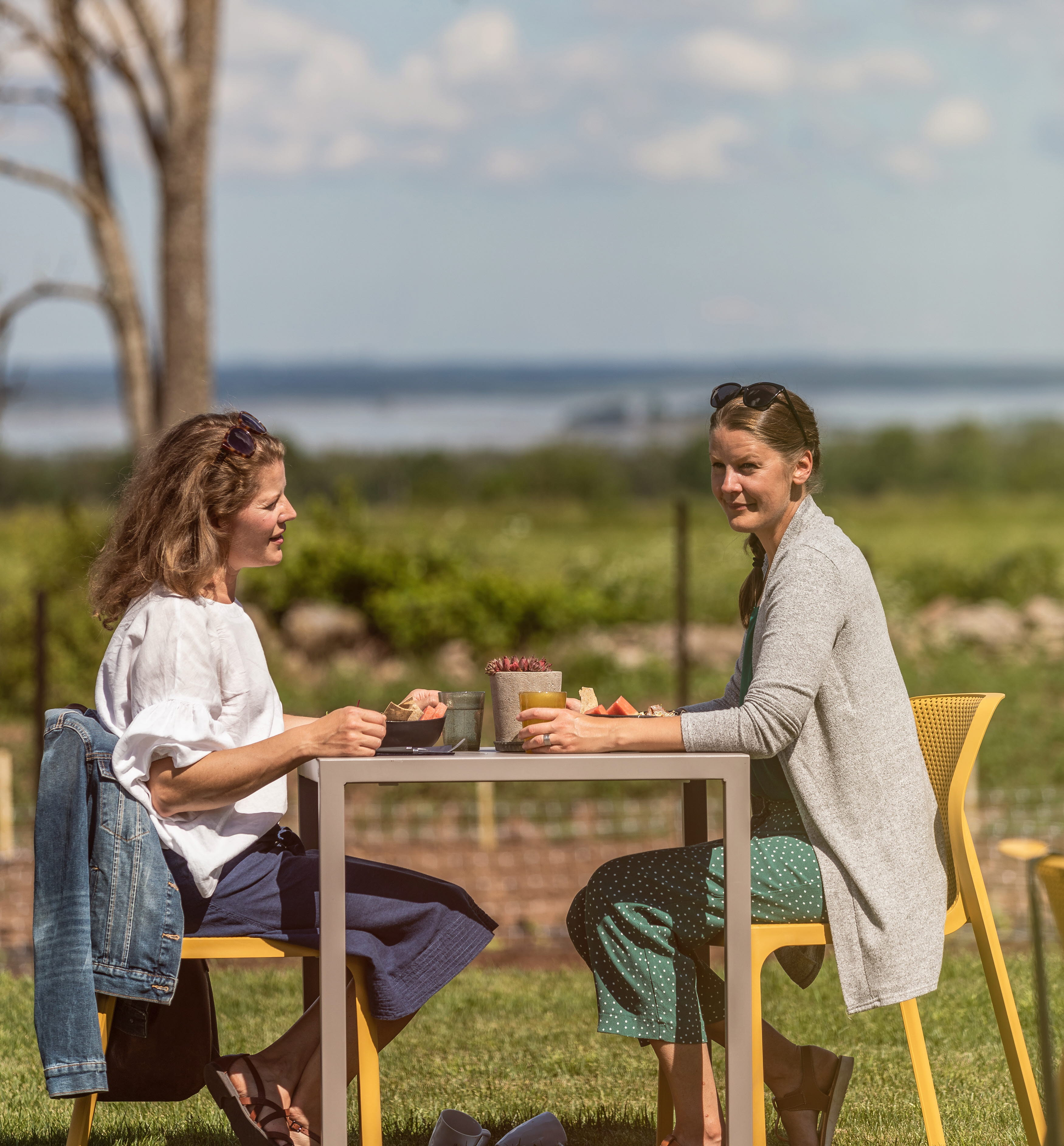 Två kvinnor som sitter på uteserveringen och fikar.
