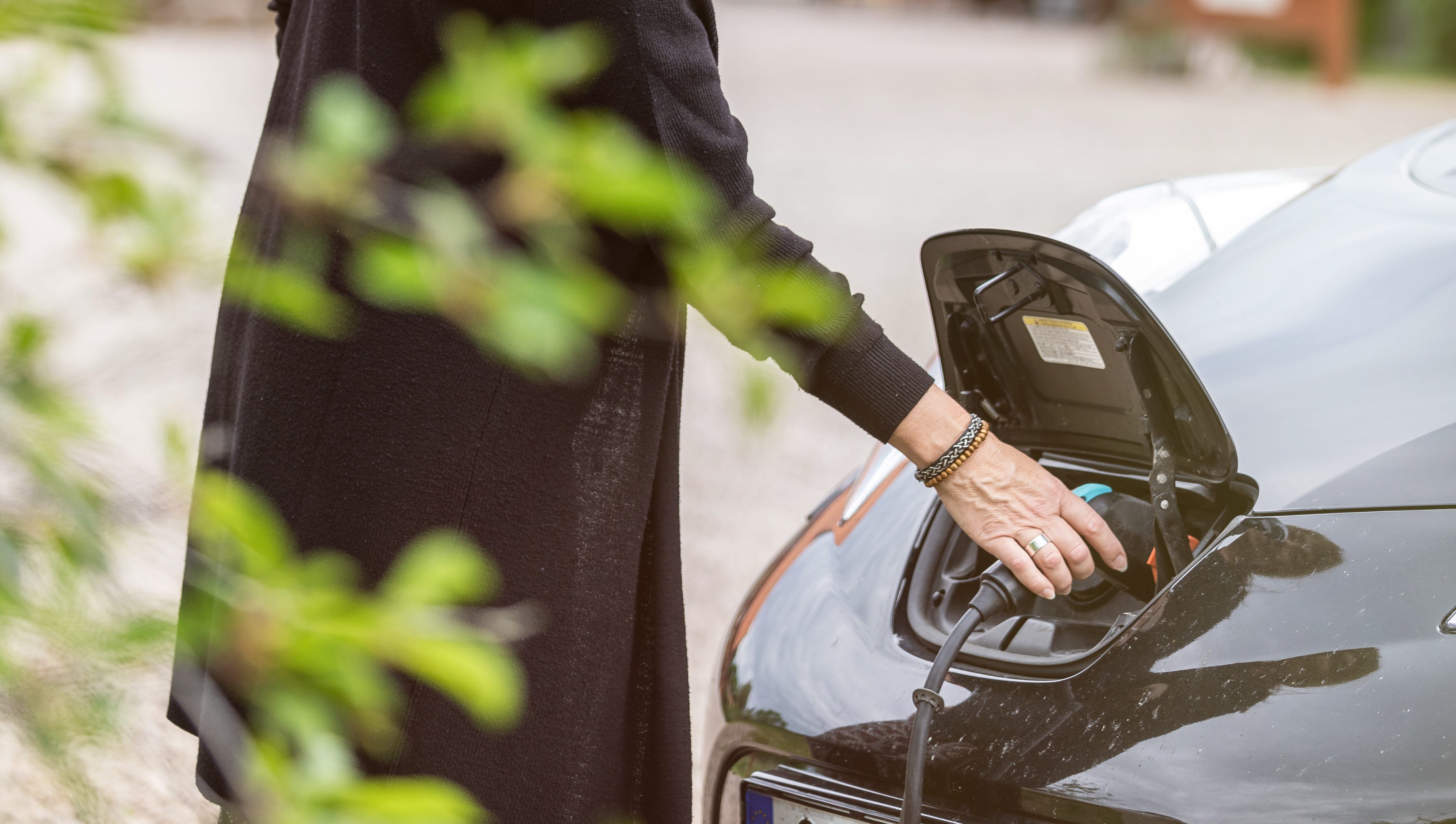 Kvinna som laddar en elbil.