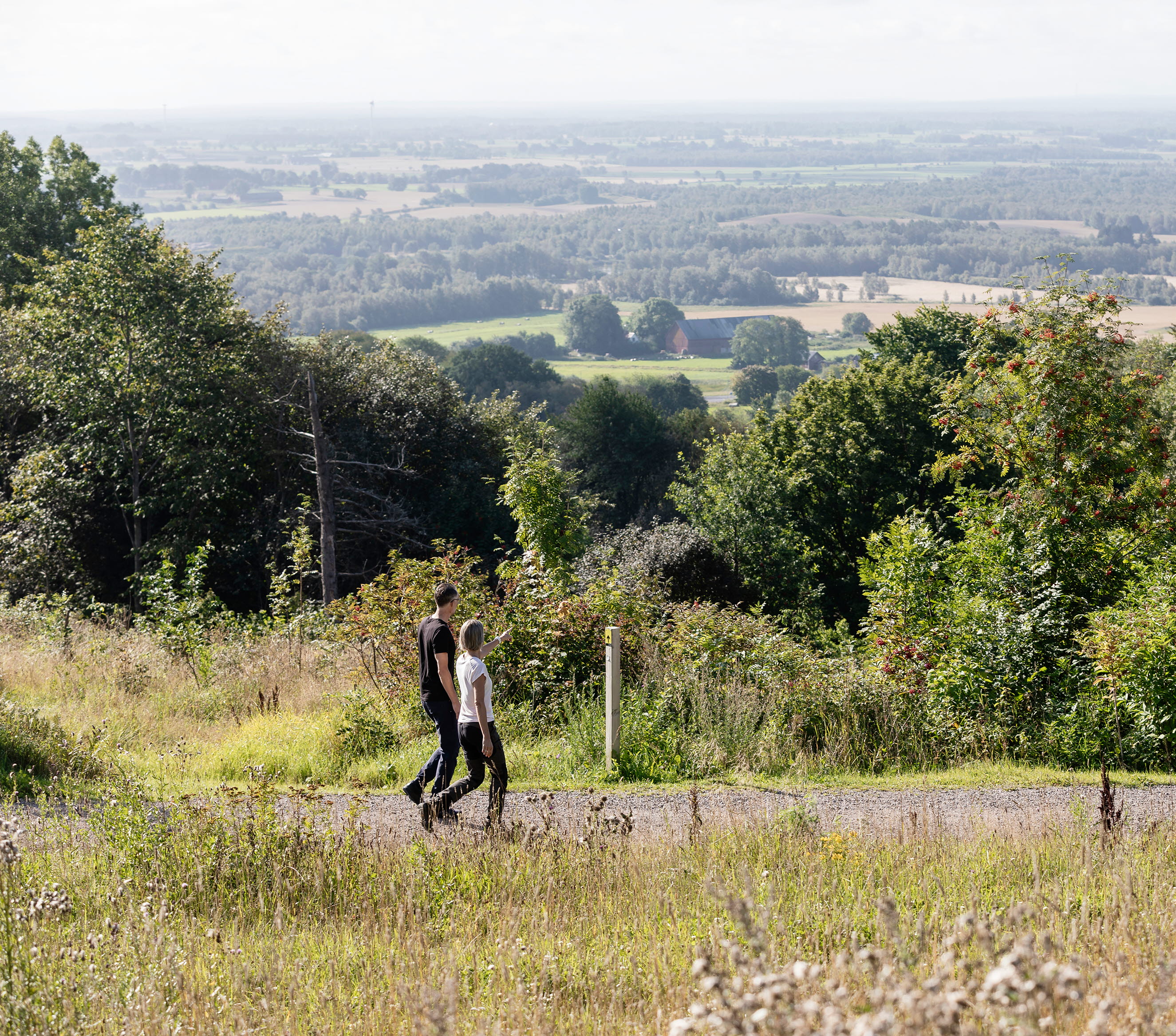 Man and woman walking on an exercise track. Beautiful view in the background.