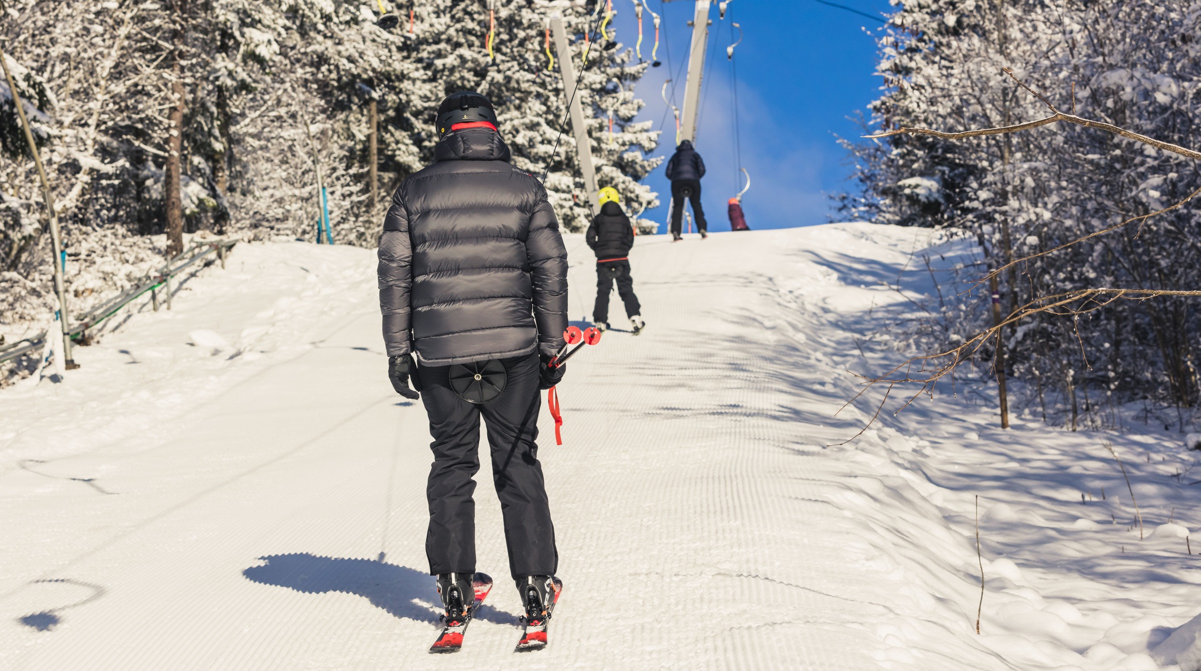 Several people go up with a lift. The people have their backs to the camera.