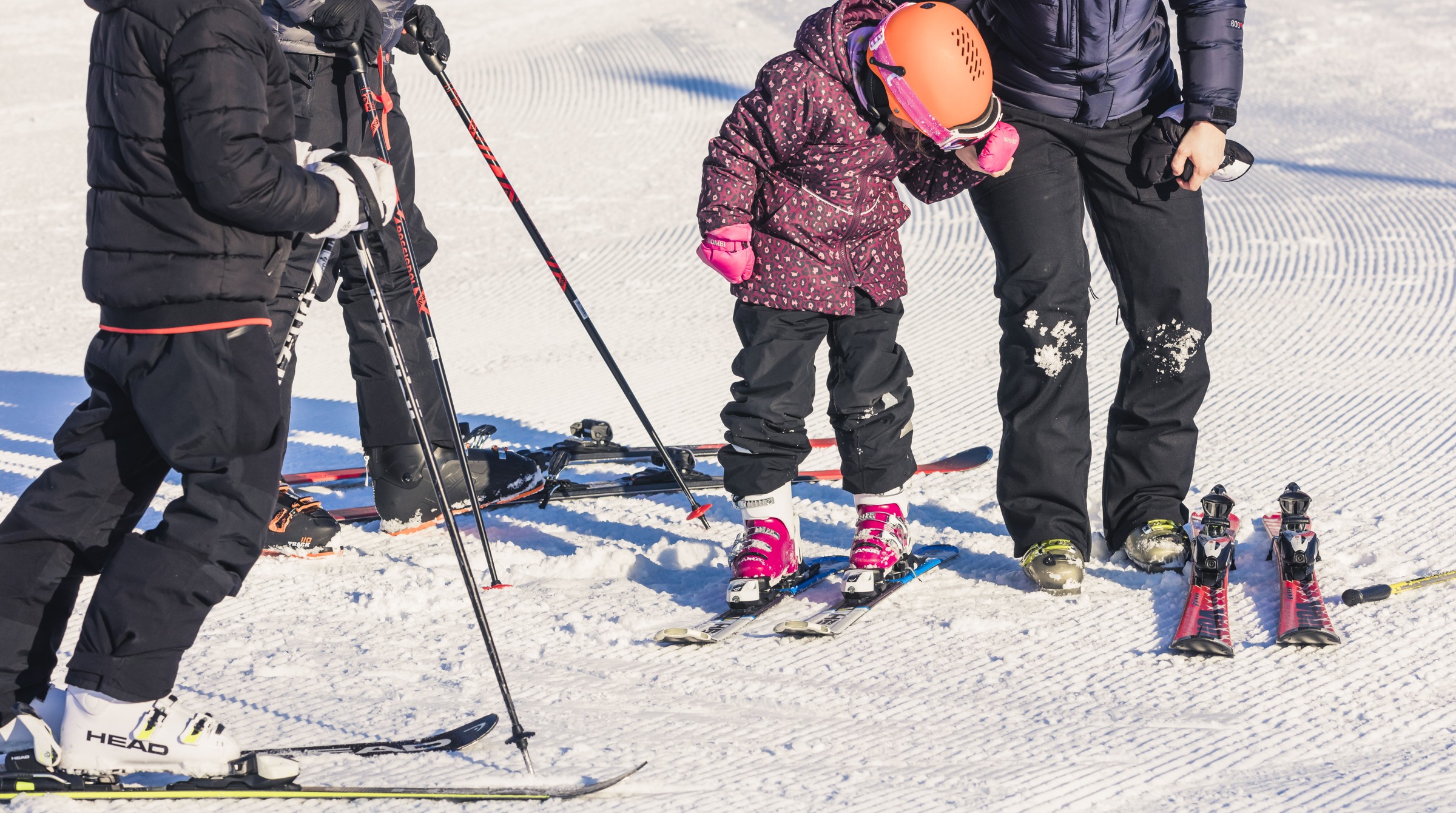 En familj på 4 personer tar på sig sina skidor.