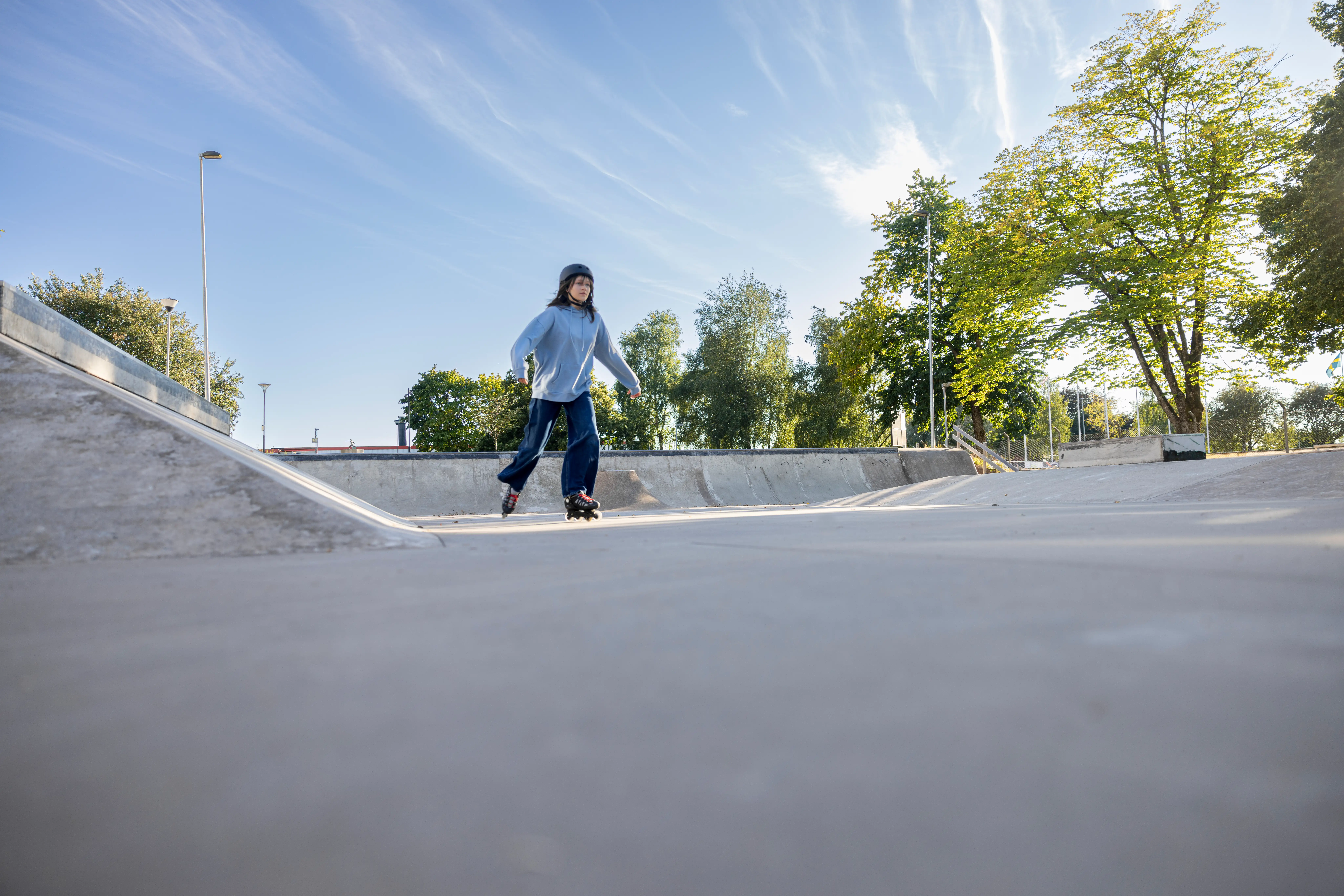 En ungdom åker Inlines i en betongpark