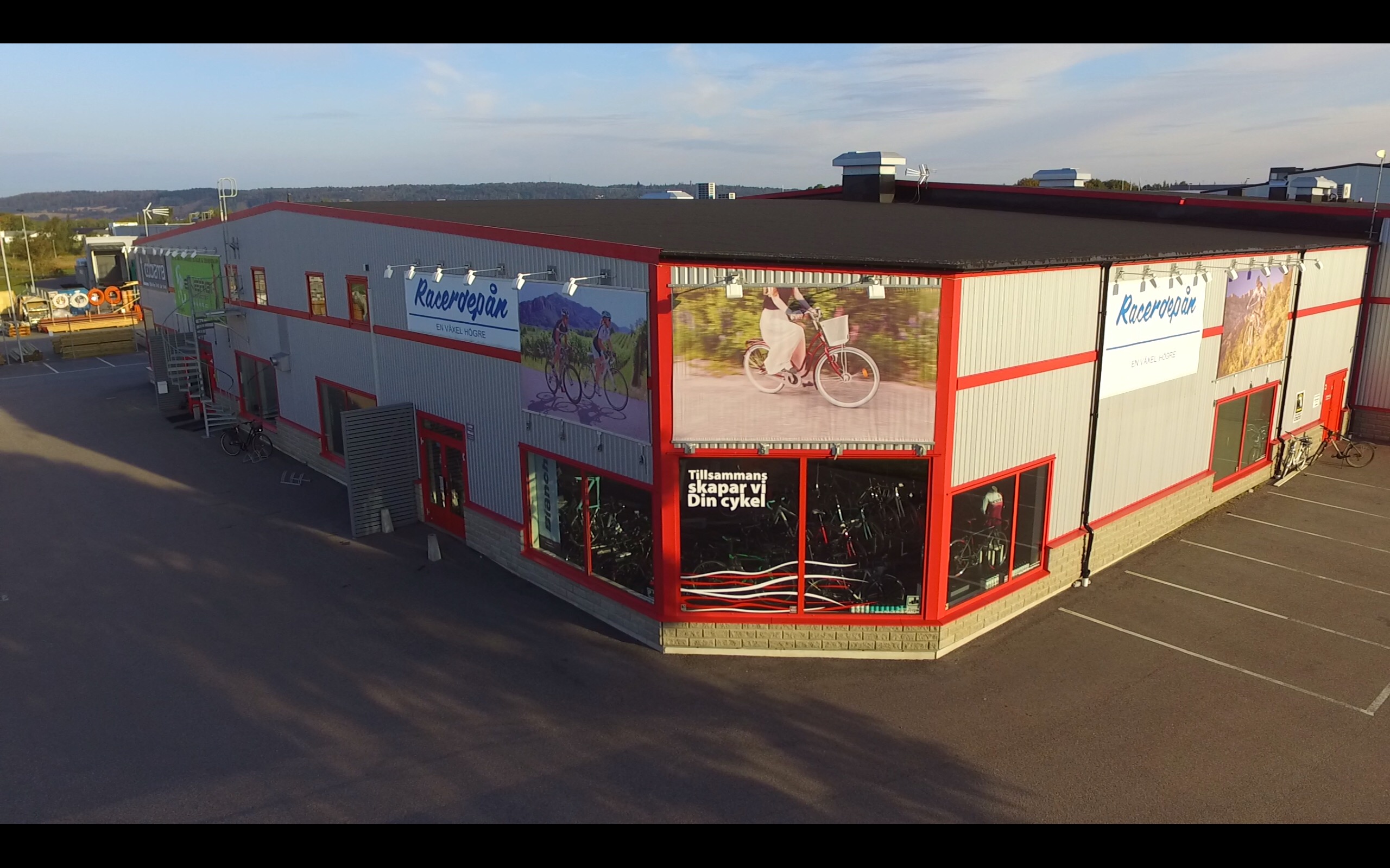 Exteriörbild av Racerdepån tagen ovanifrån. Grå byggnad med röda detaljer.