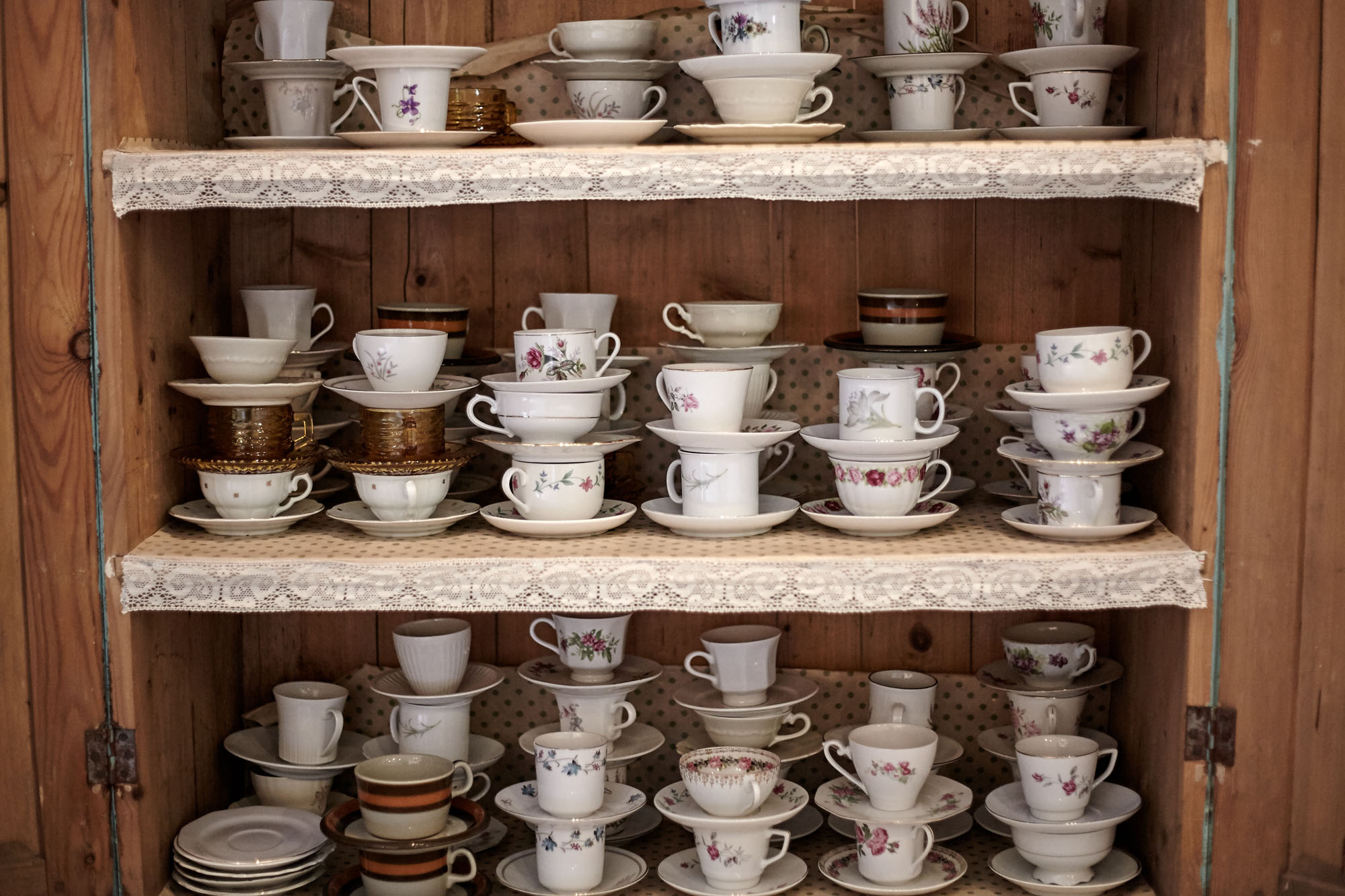 Full of coffee cups stacked in a cupboard.