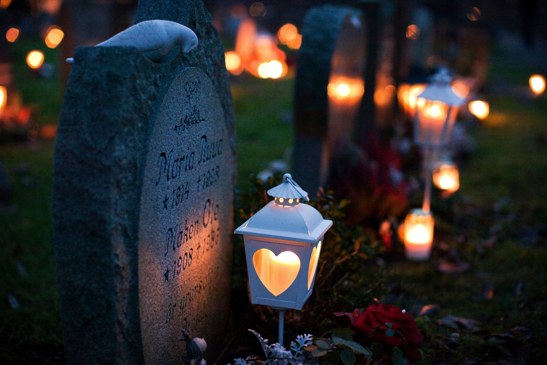 gravsten med ljuslykta i mörkret