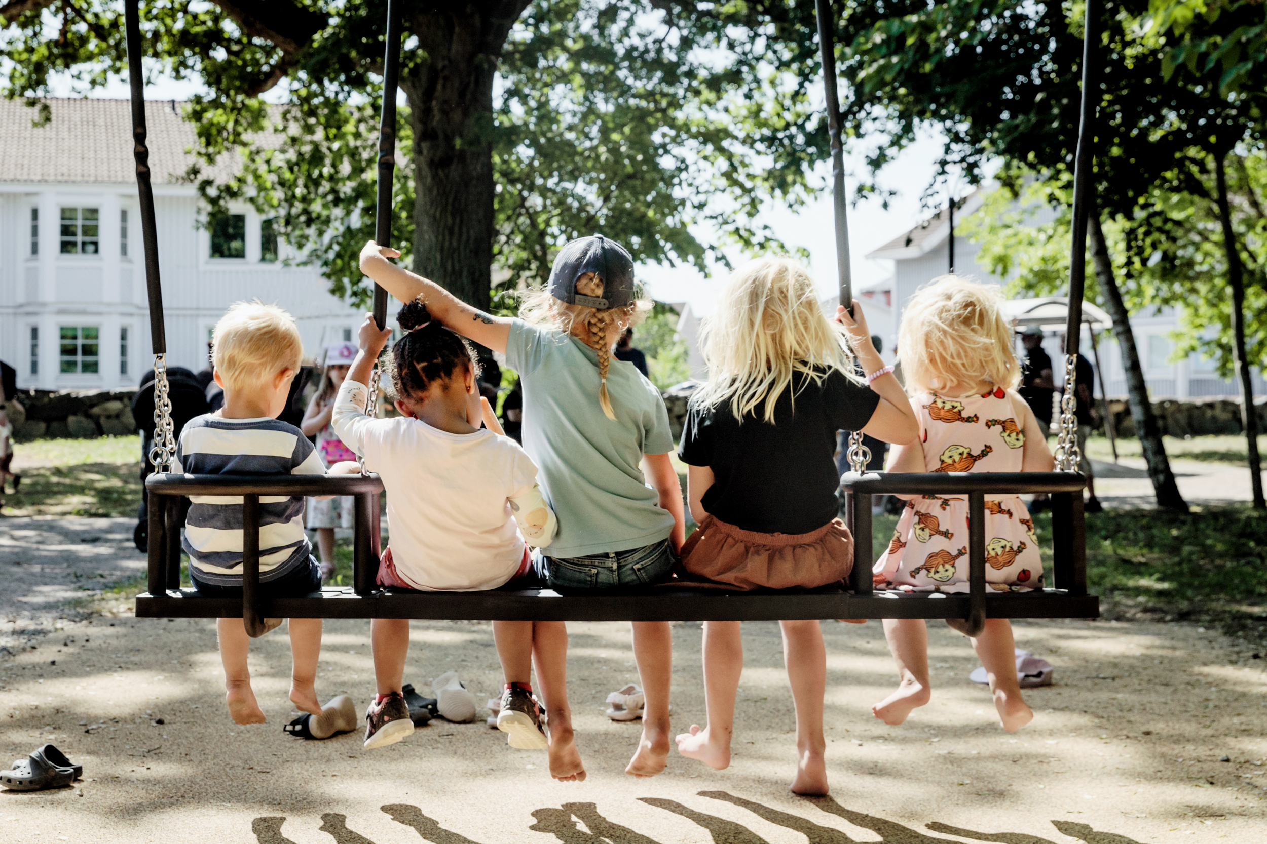 barn gungar på en stor gunga iklädda sommarkläder