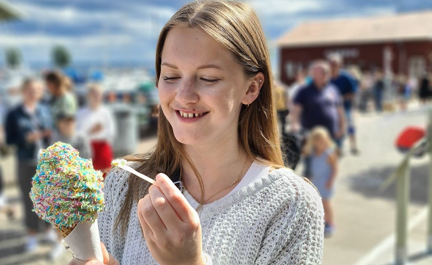 Flicka äter glass i Hjo hamn. 