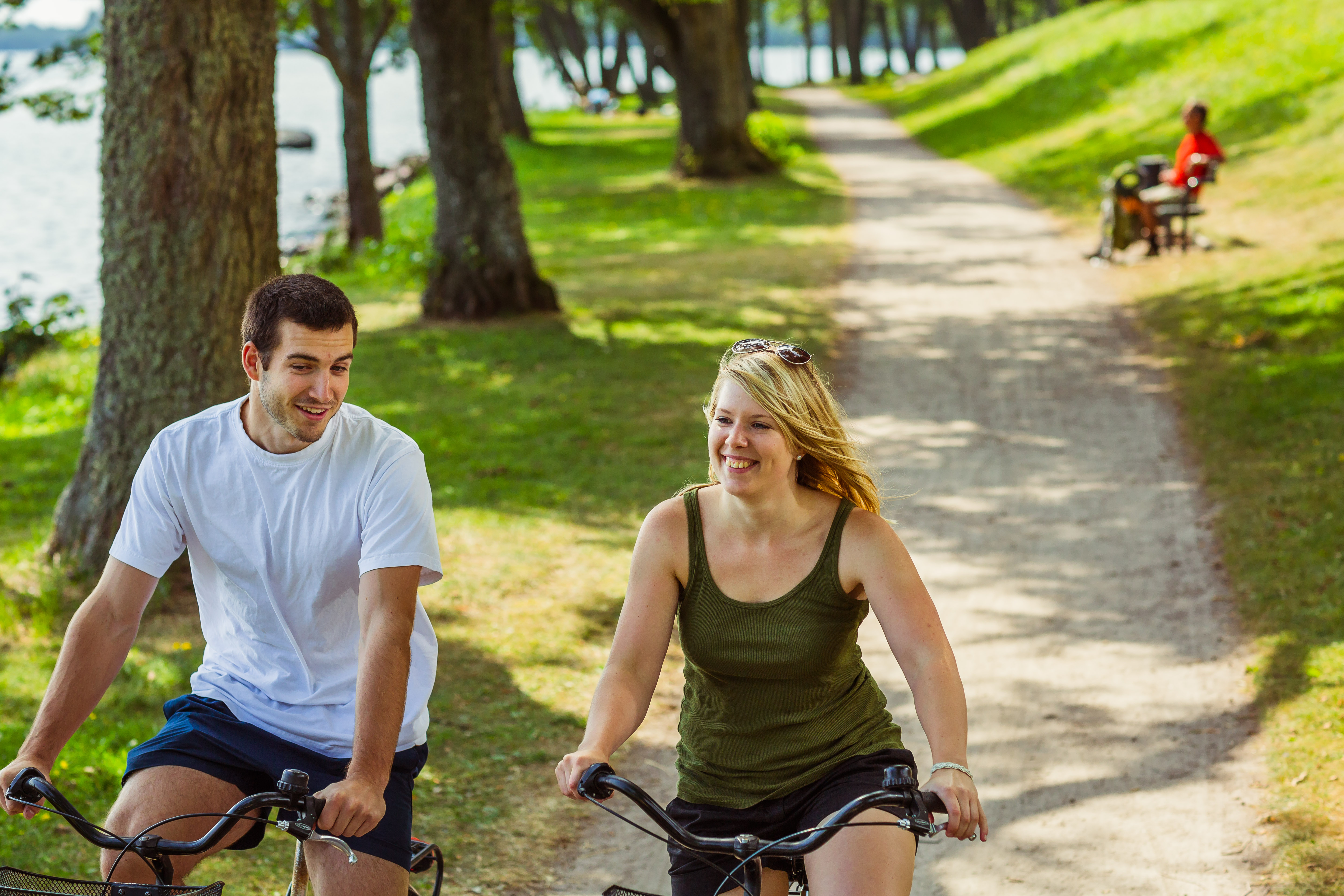 Par som cyklar längs strandpromenaden i Hjo. 