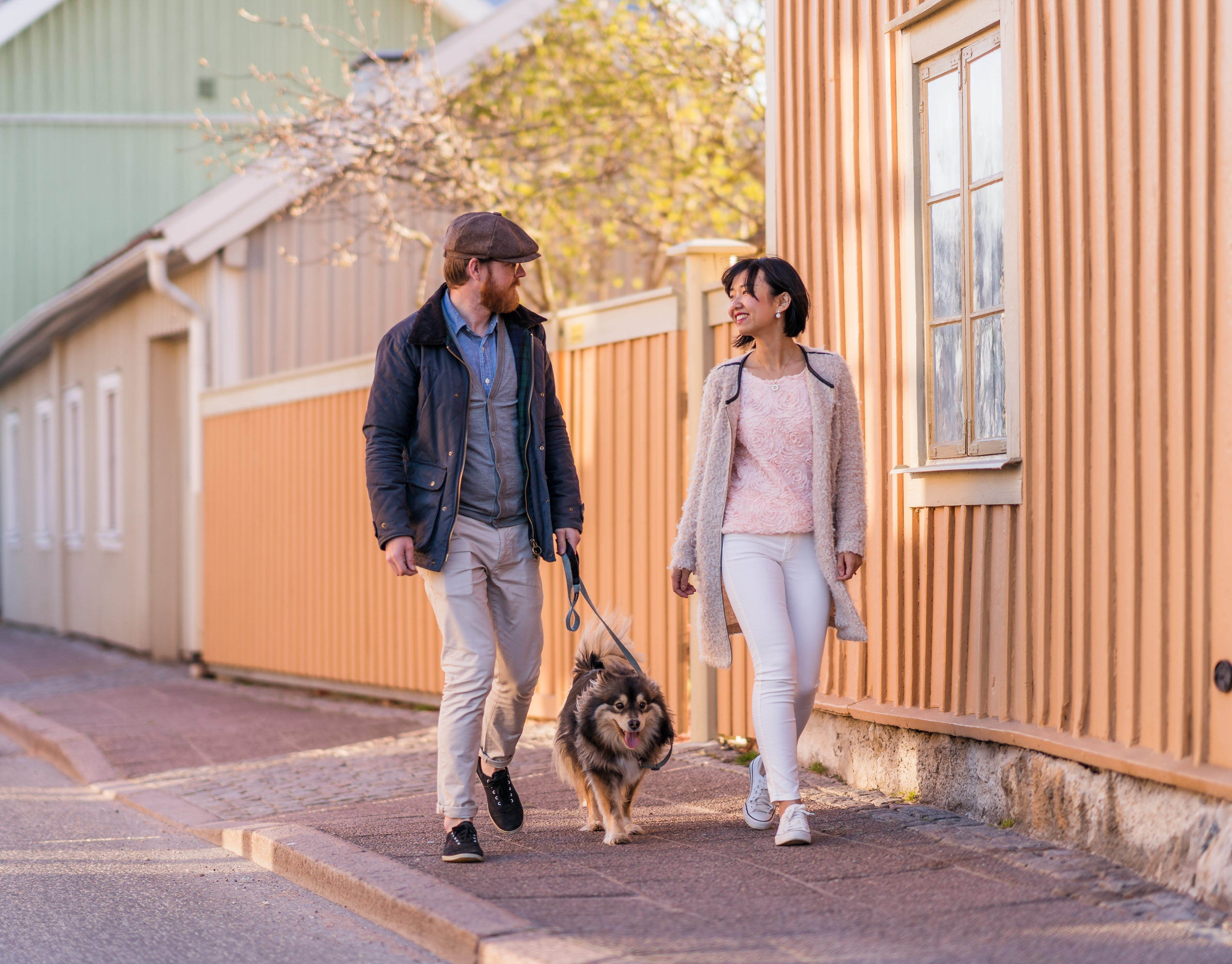Ett par på vårpromenad med sin hund längs med Långgatan mitt i den gamla trästaden i Hjo. 