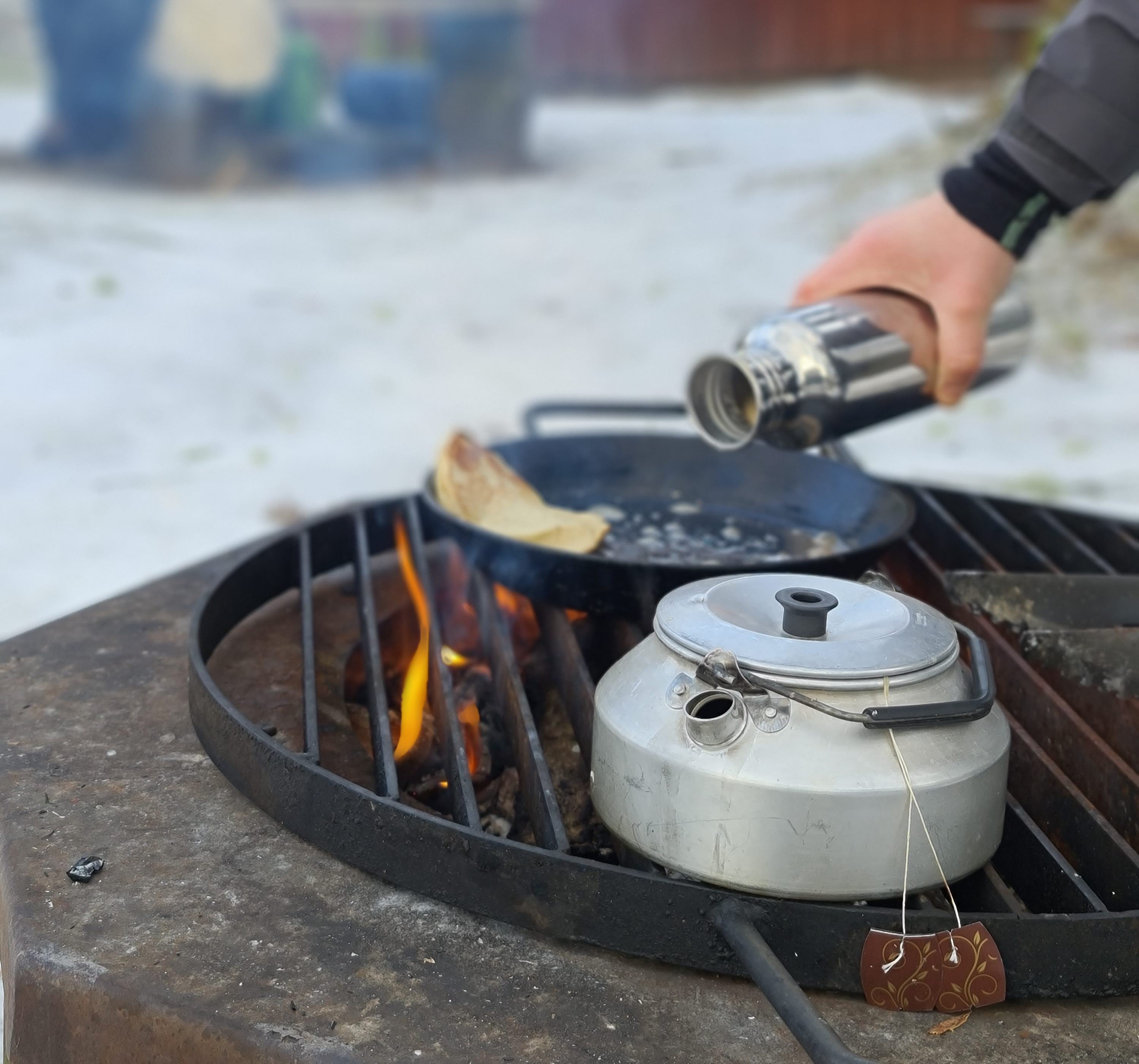 Matlagning över eldstad utomhus. 