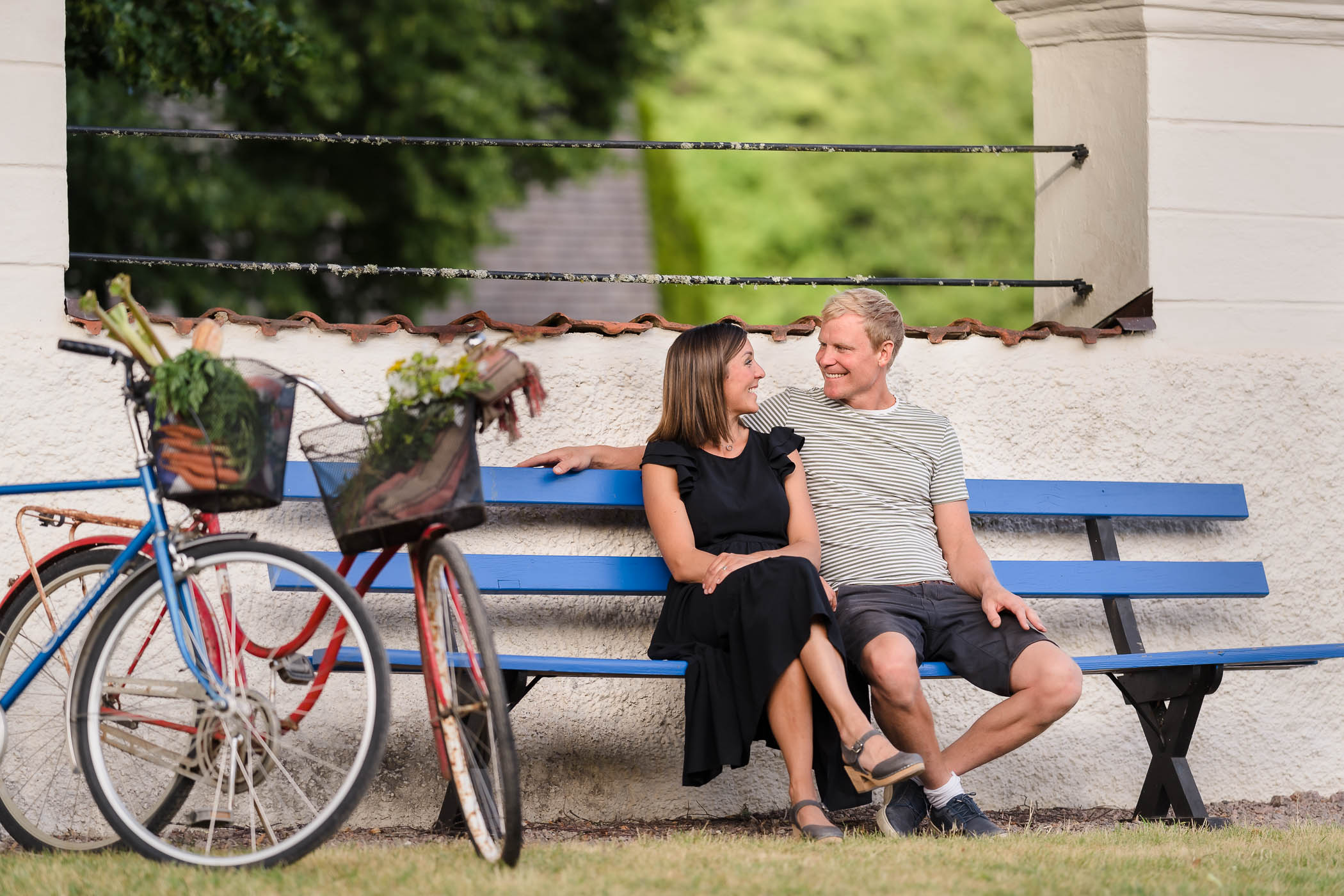 Par på cykeltur vilar på en bänk.
