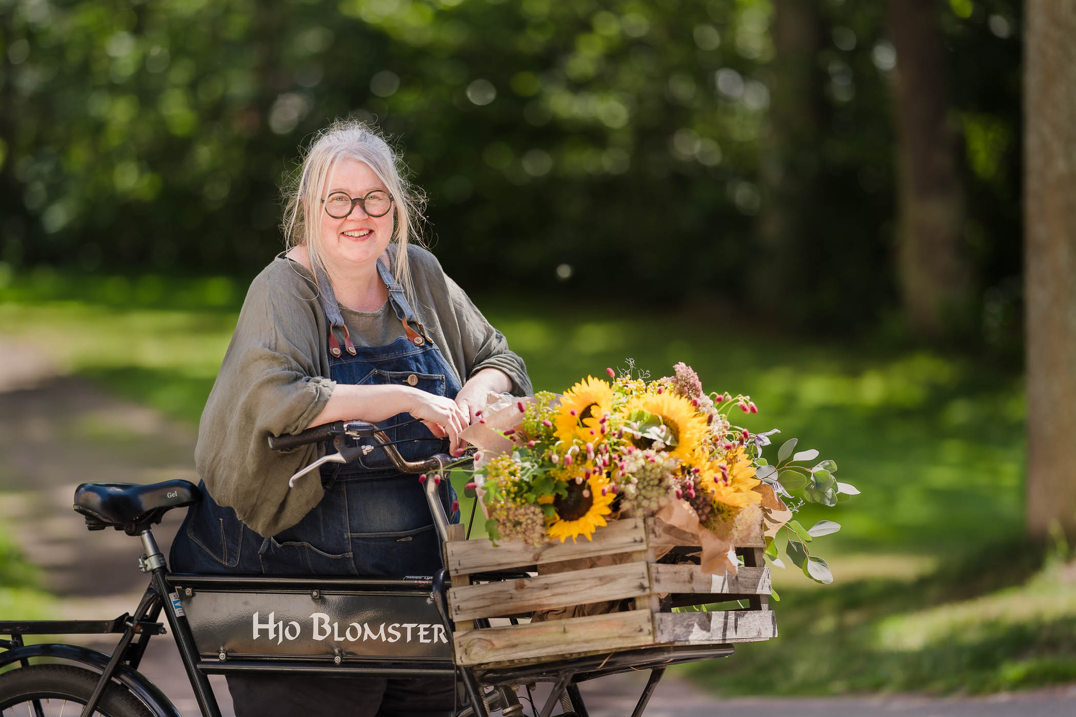 Kvinna med blommor på en cykel 