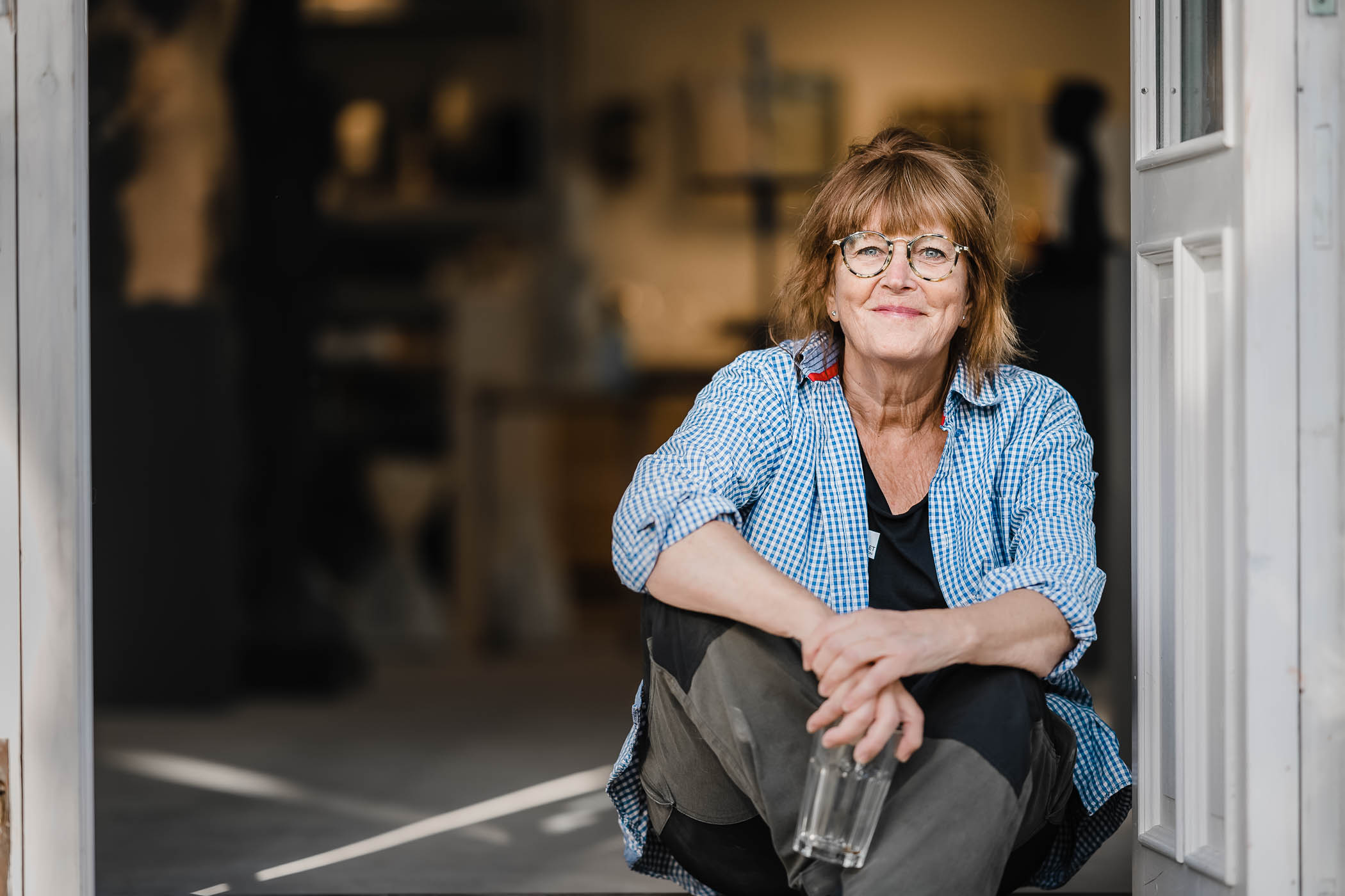 Kvinna sitter i en dörröppning. 