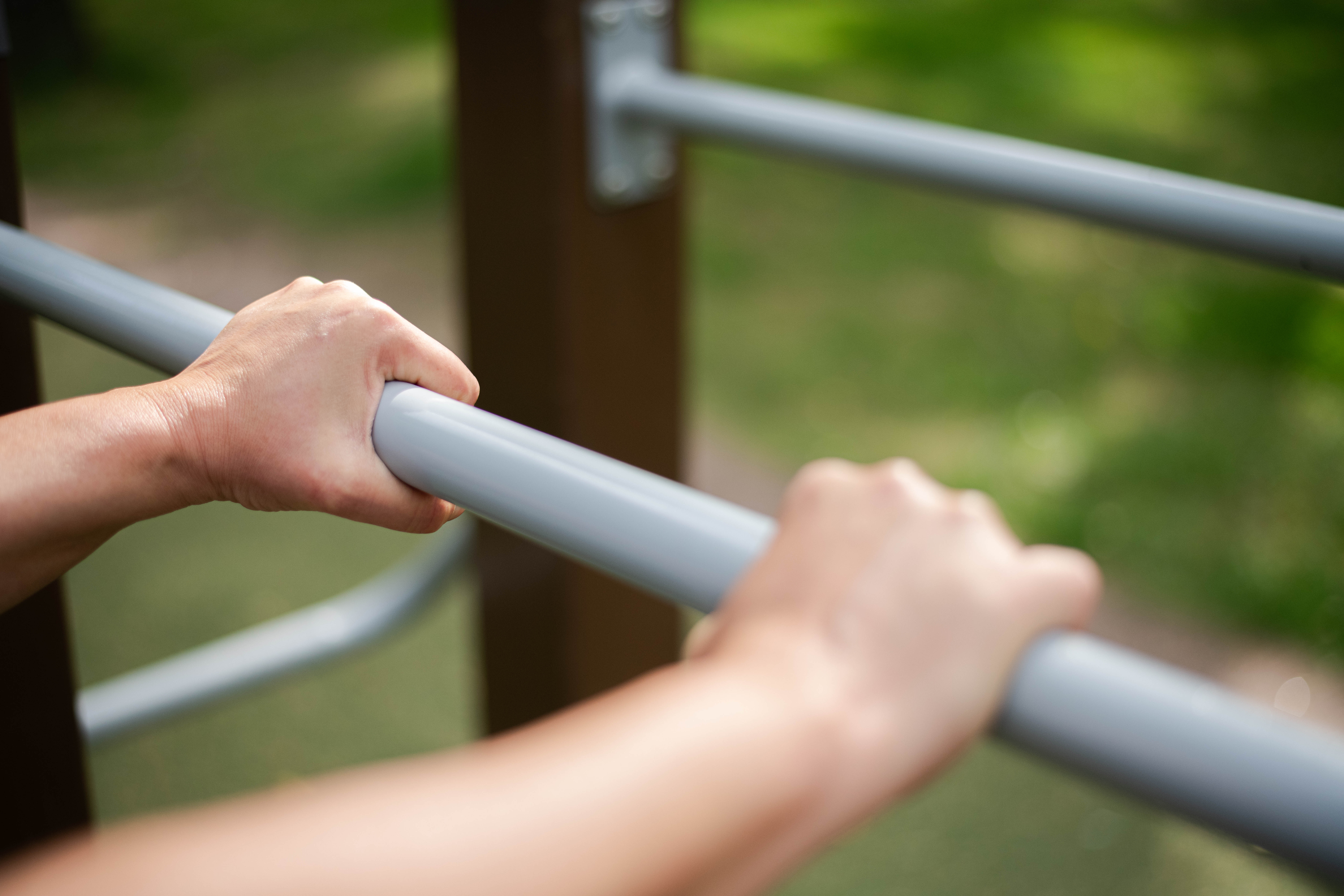 två händer som håller i en träningsstång