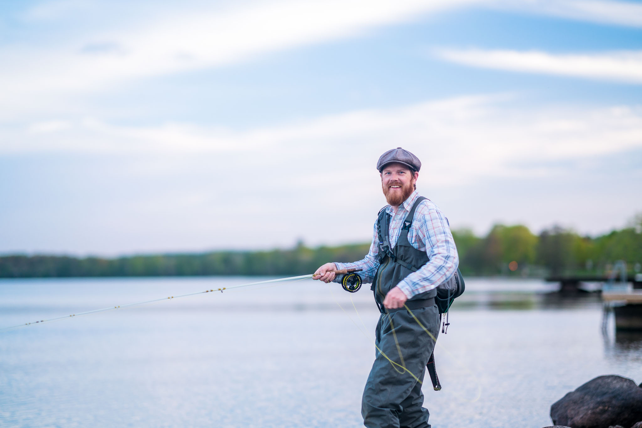 En man flugfiskar i hamnen i Hjo. 