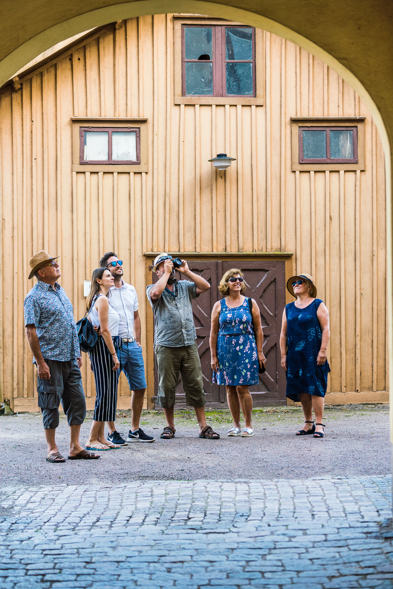 En grupp turister som fotar trähus i Hjo. 