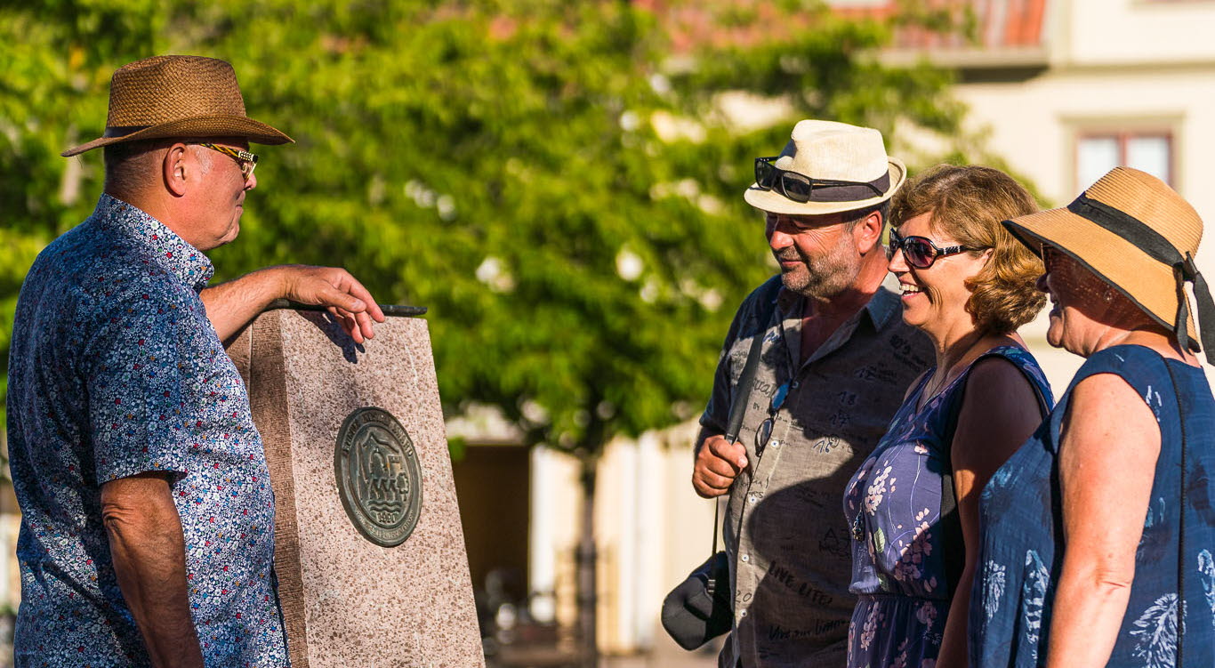 Människor som tittar på Europa Nostra plakett på torget i Hjo. 