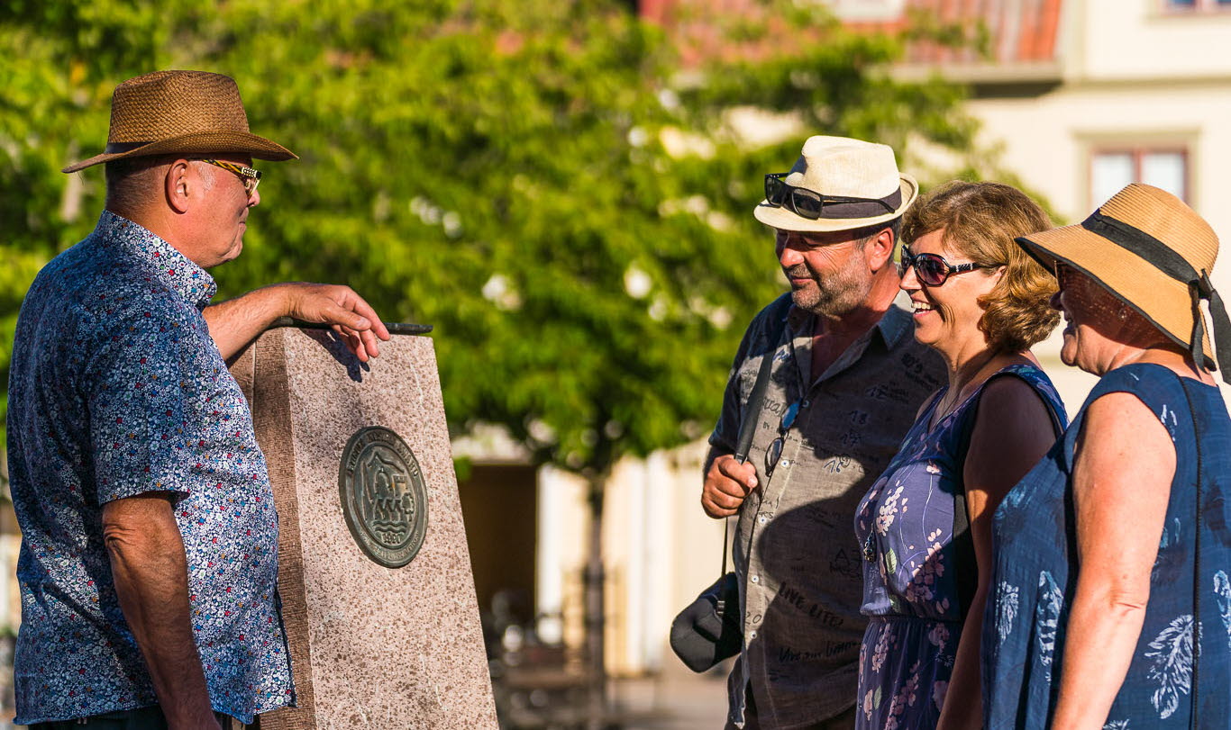 Människor som tittar på Europa Nostra plakett på torget i Hjo. 